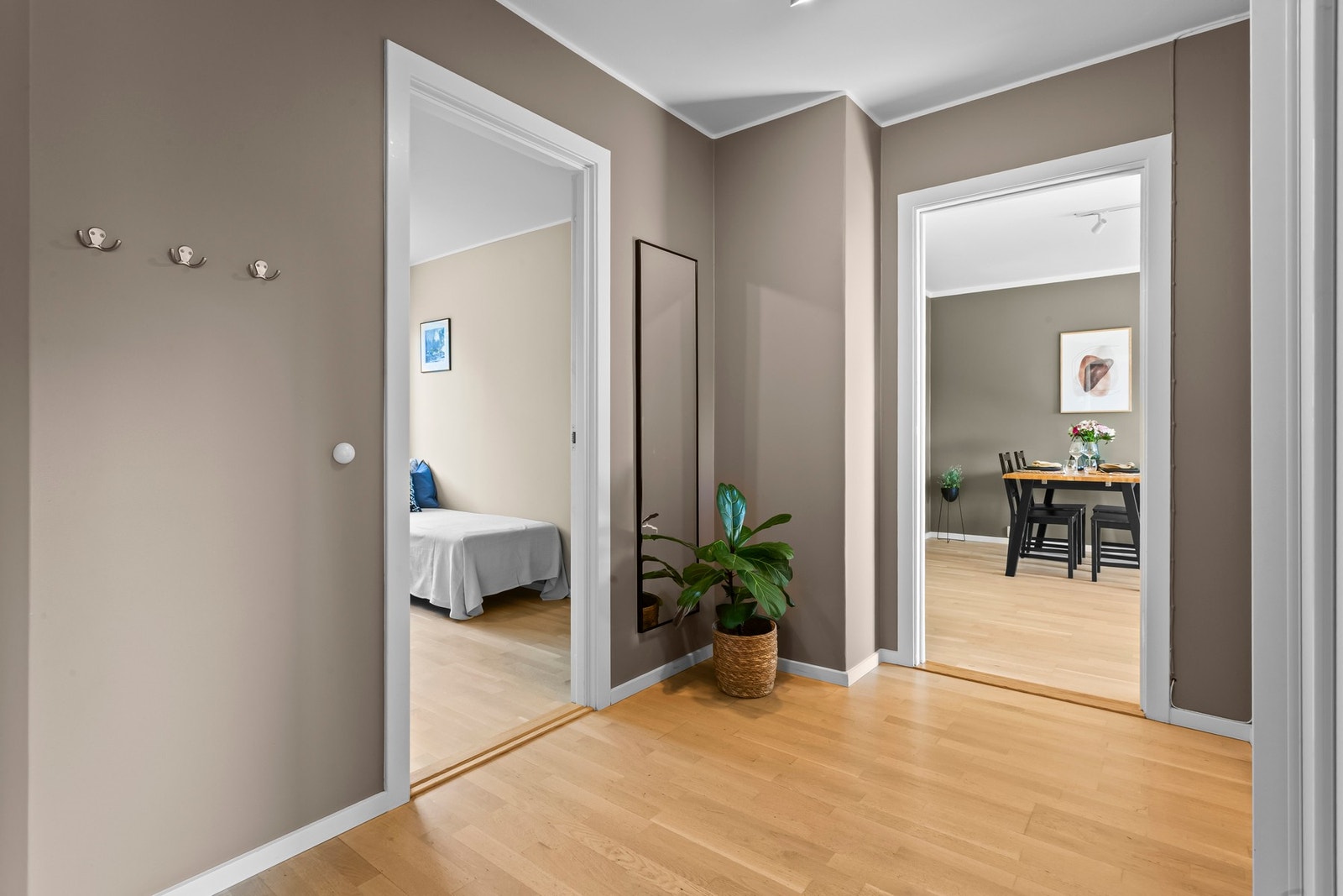 Leiligheten har en romslig gang med lyst parkettgulv og slette vegger malt i en moderne tone. Galleribilde