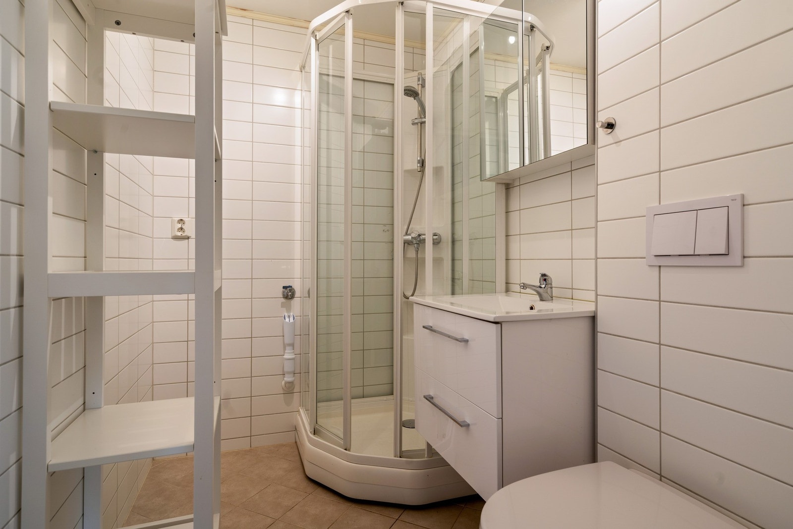 Det er fliser på badets vegger og gulv, samt varme i gulvet. Galleribilde