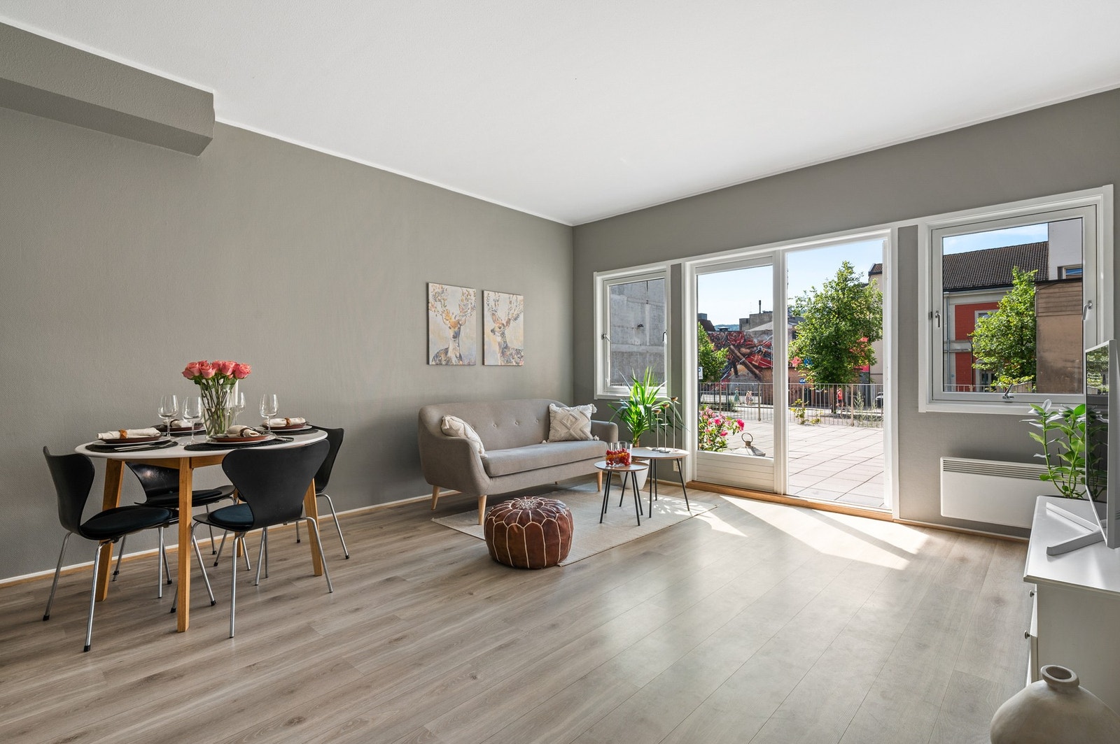 Lys og innbydende stue med laminat på gulv og slette malte tak og vegger Galleribilde
