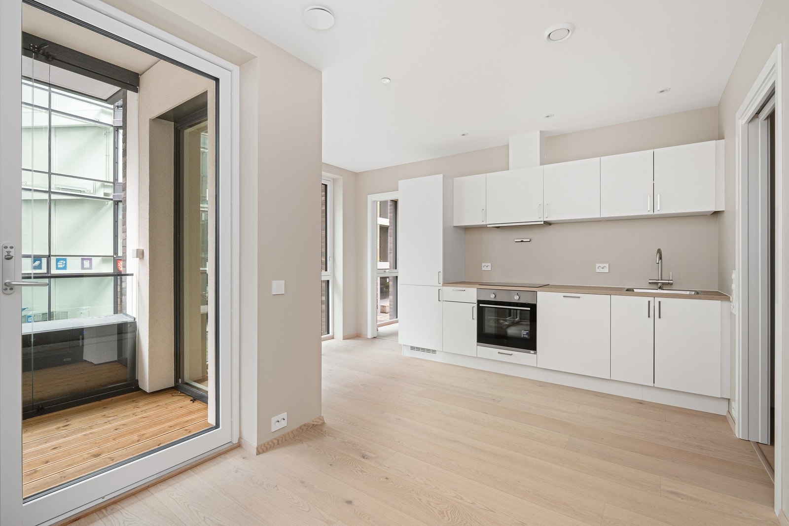 Fin åpen stue og kjøkken løsning med flere møbleringsmuligheter Galleribilde