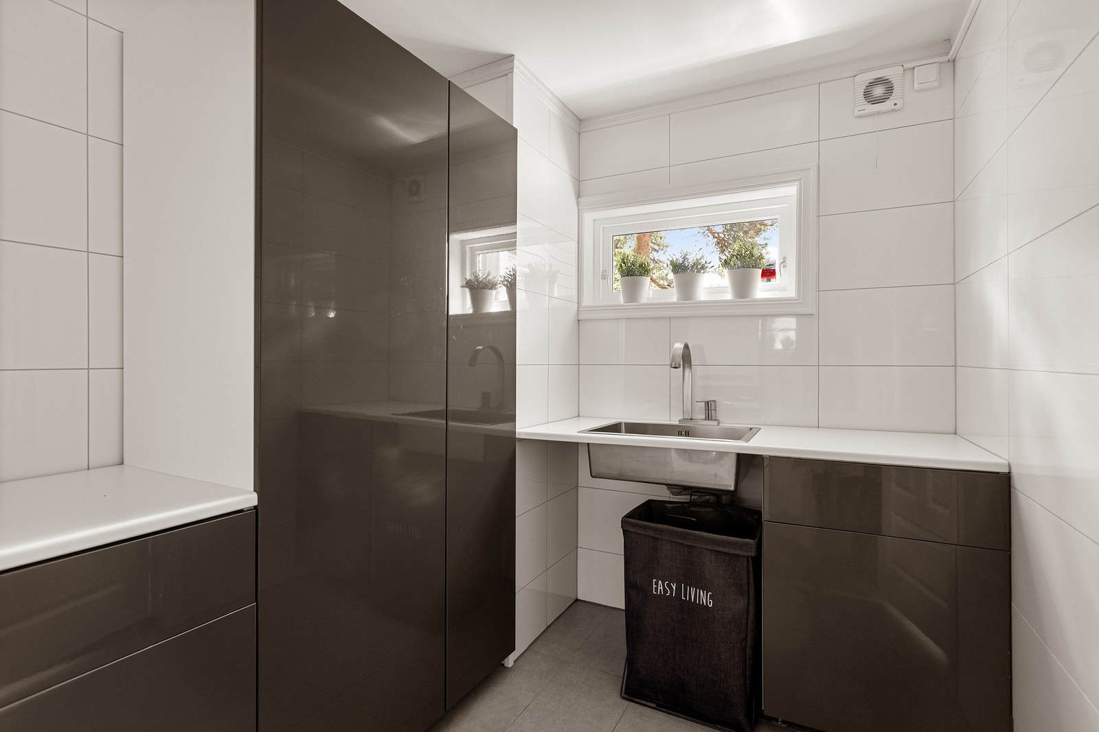 Fra badet er det direkte inngang til vaskerommet, som ble etablert i en tidligere bod i 2016 og pent utført med mørke gulvfliser, lyse veggfliser, gulvvarme, hvitmalt himling og et smalt vindu. Galleribilde