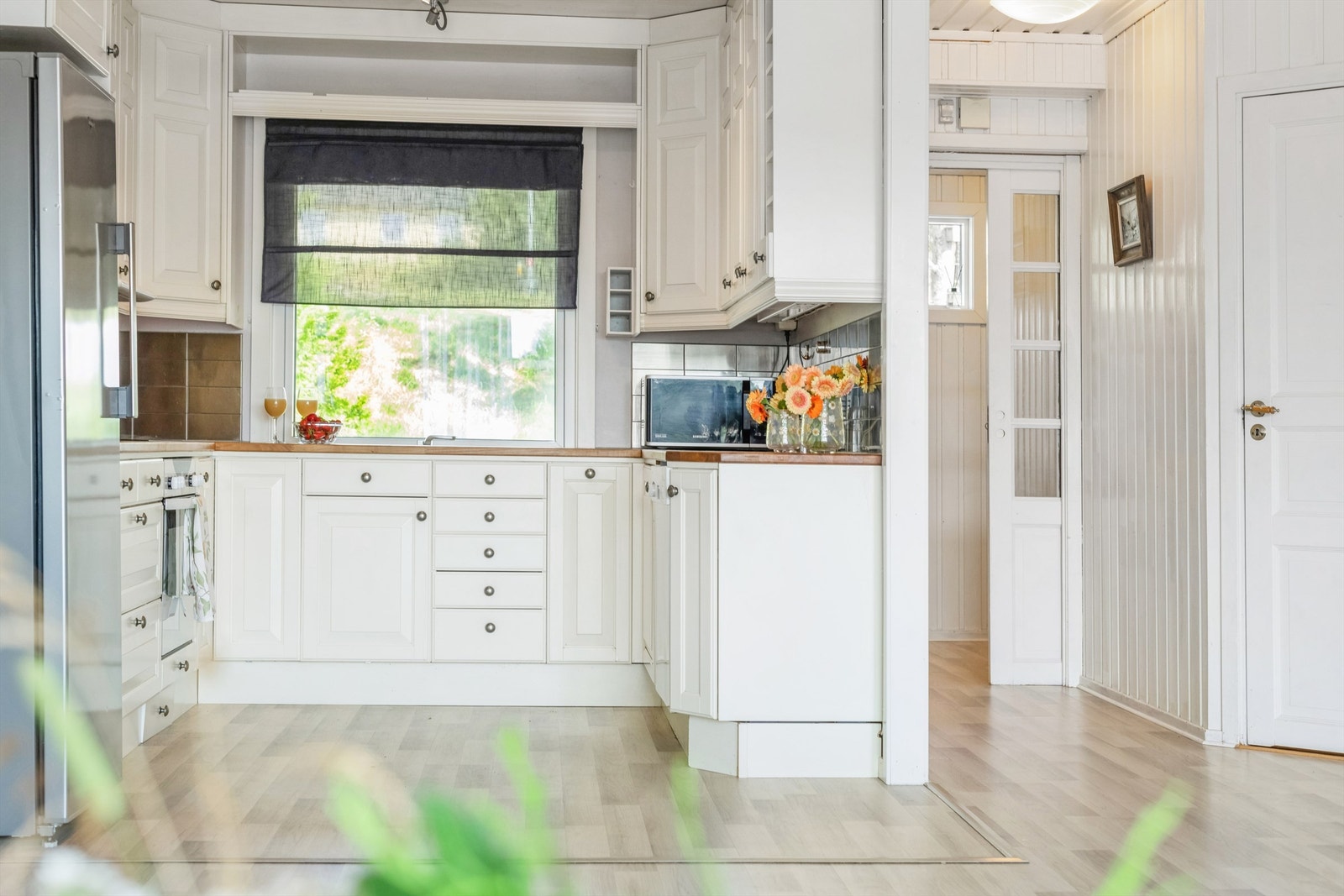 Praktisk kjøkken med oppvaskmaskin under vask i innredningen. Kjøleskapet er frittstående Galleribilde