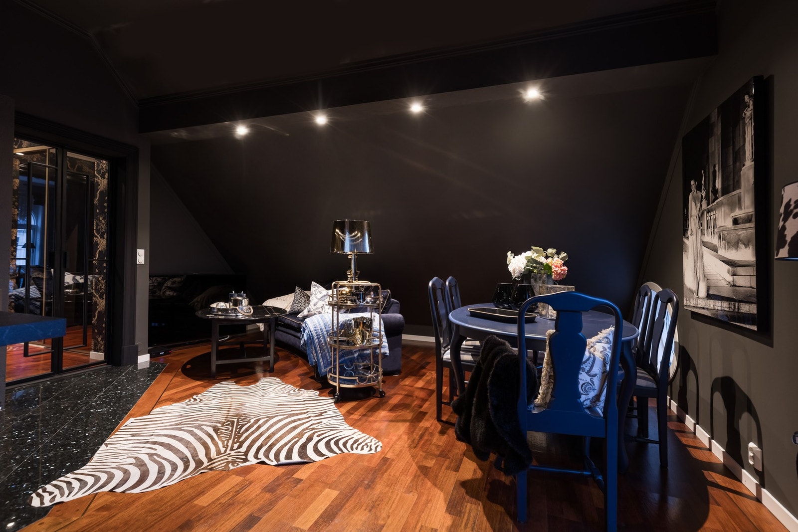 Stuen fremstår moderne og gjennomført, og er nymalt i en eksklusiv, mørk sortfarge som gir rommet en elegant og lun atmosfære. Galleribilde