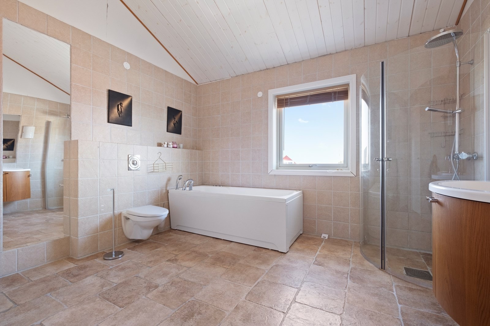 Badet er utstyrt med dusjdører i dusjnisje, boblebadekar fra 2013 og veggmontert toalett Galleribilde