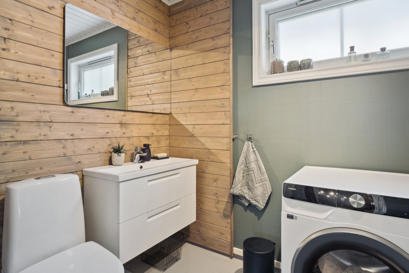 Koselig vaskerom/bad med malt gulvbelegg, malt våtromstapet og overflatebehandlet trepanel på veggene. Galleribilde