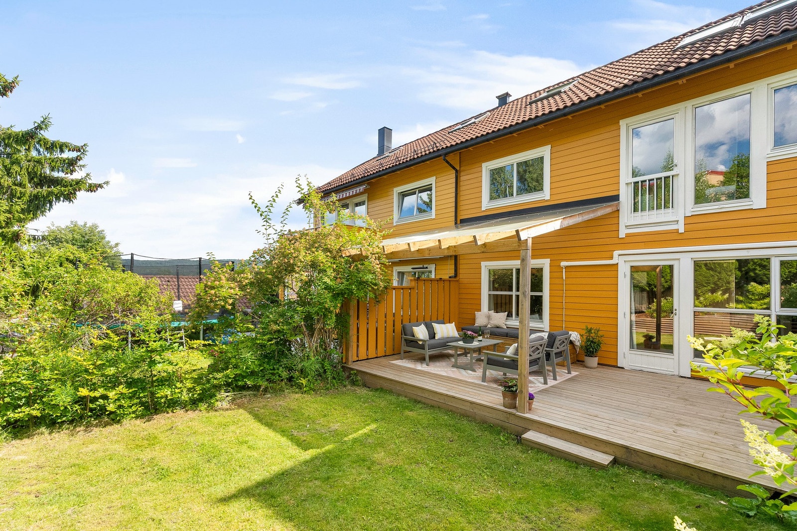 Frodig, solrik hage hvor eier senere år har fjernet store jordmasser og etablert nye blomsterkasser og økt benyttbart areal med 30% Galleribilde