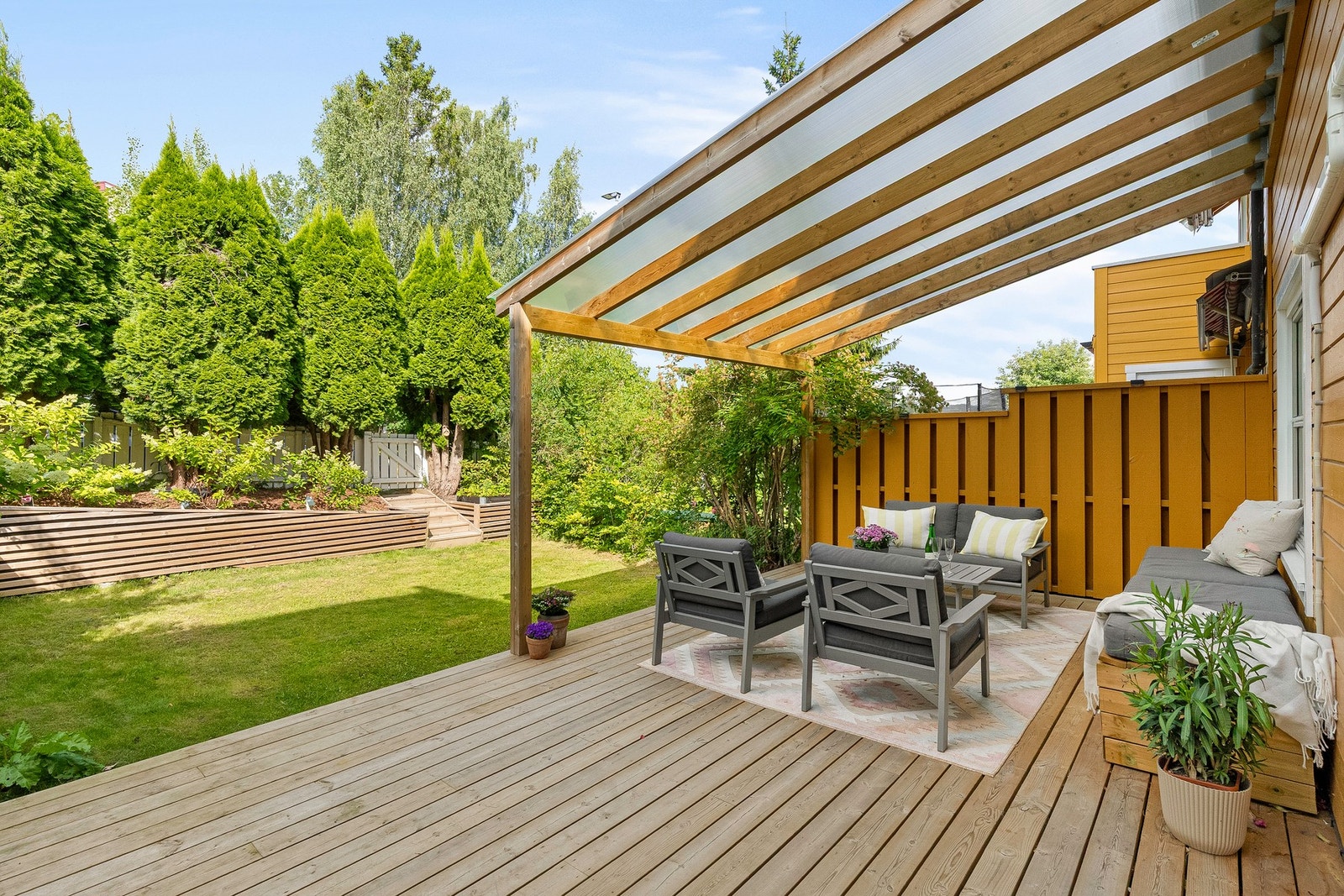 Stor, fint terrasse på 27 kvm fra 2023 med smart overbygg i et UV-beskyttende materiale som gir et meget hyggelige utemiljø Galleribilde