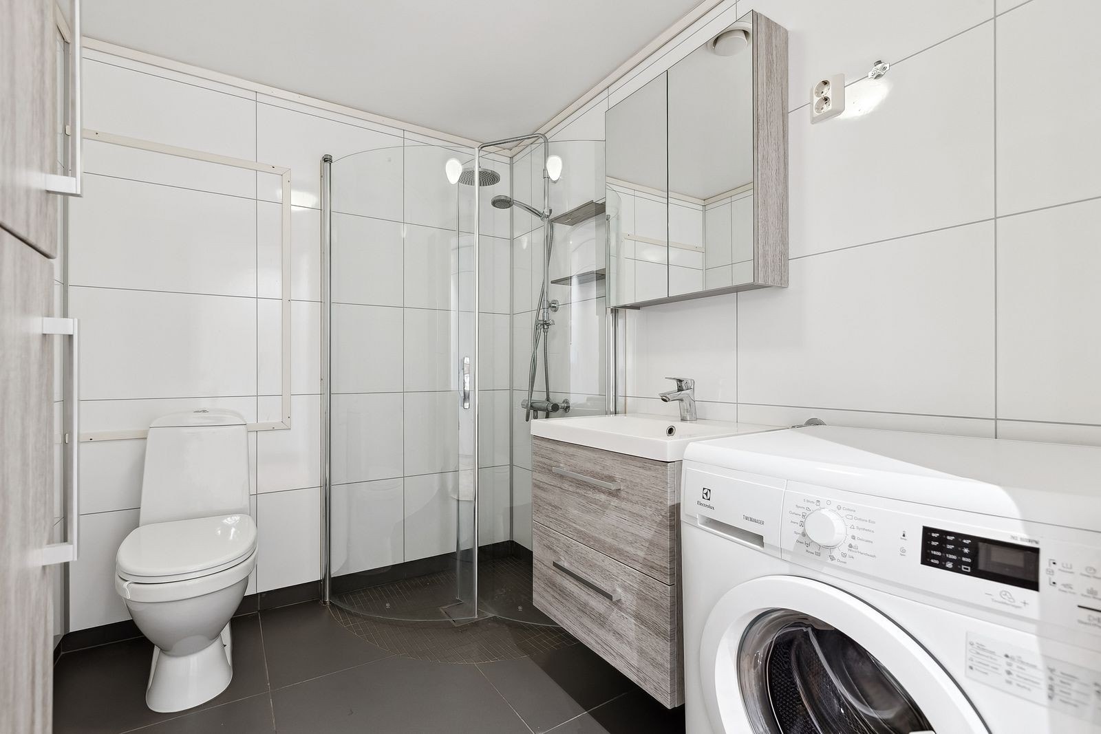 Badet ligger til venstre før stuen, og fremstår som stilrent med gode muligheter for oppbevaring. Galleribilde