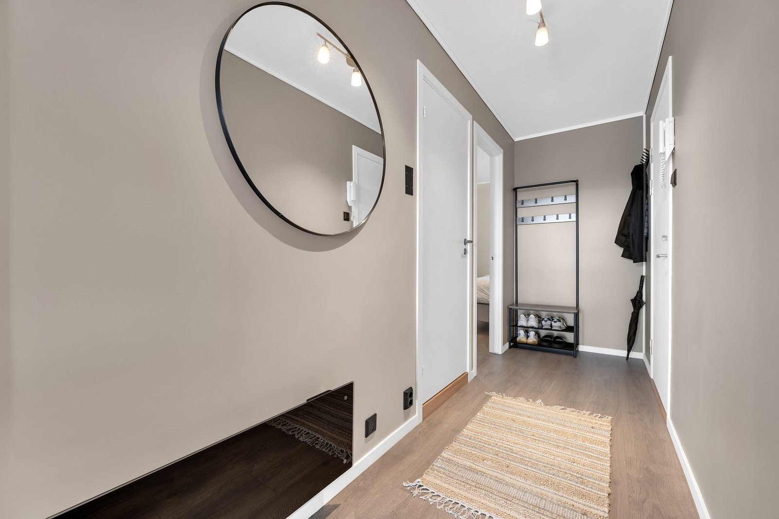 Lys og innbydende entré med moderne, farger og plass til oppbevaringsløsning for sko og yttertøy. Leiligheten oser av å være gjennomført og har mange tidsriktige detaljer. Galleribilde