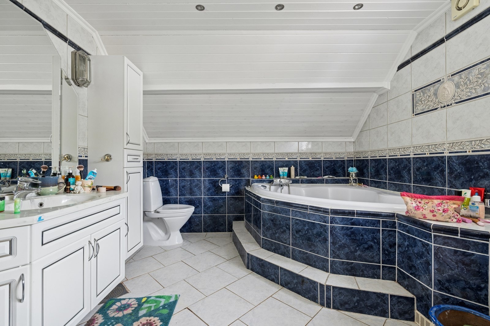 Flislagt bad med gulvvarme i 2. etasje, innredning med servant, innmurt badekar og toalett Galleribilde