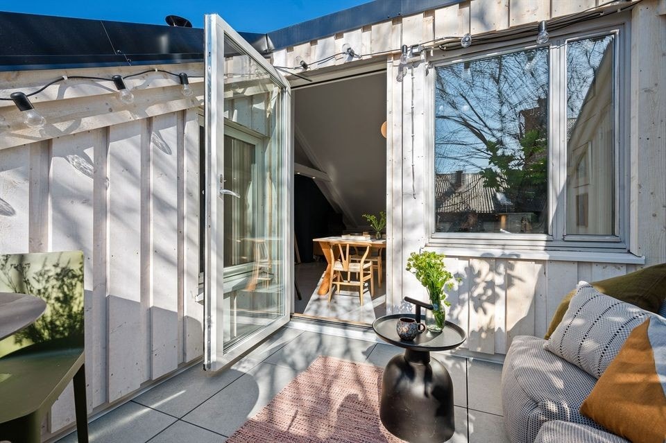 Terrassen er flislagt og har utgang fra stuen Galleribilde
