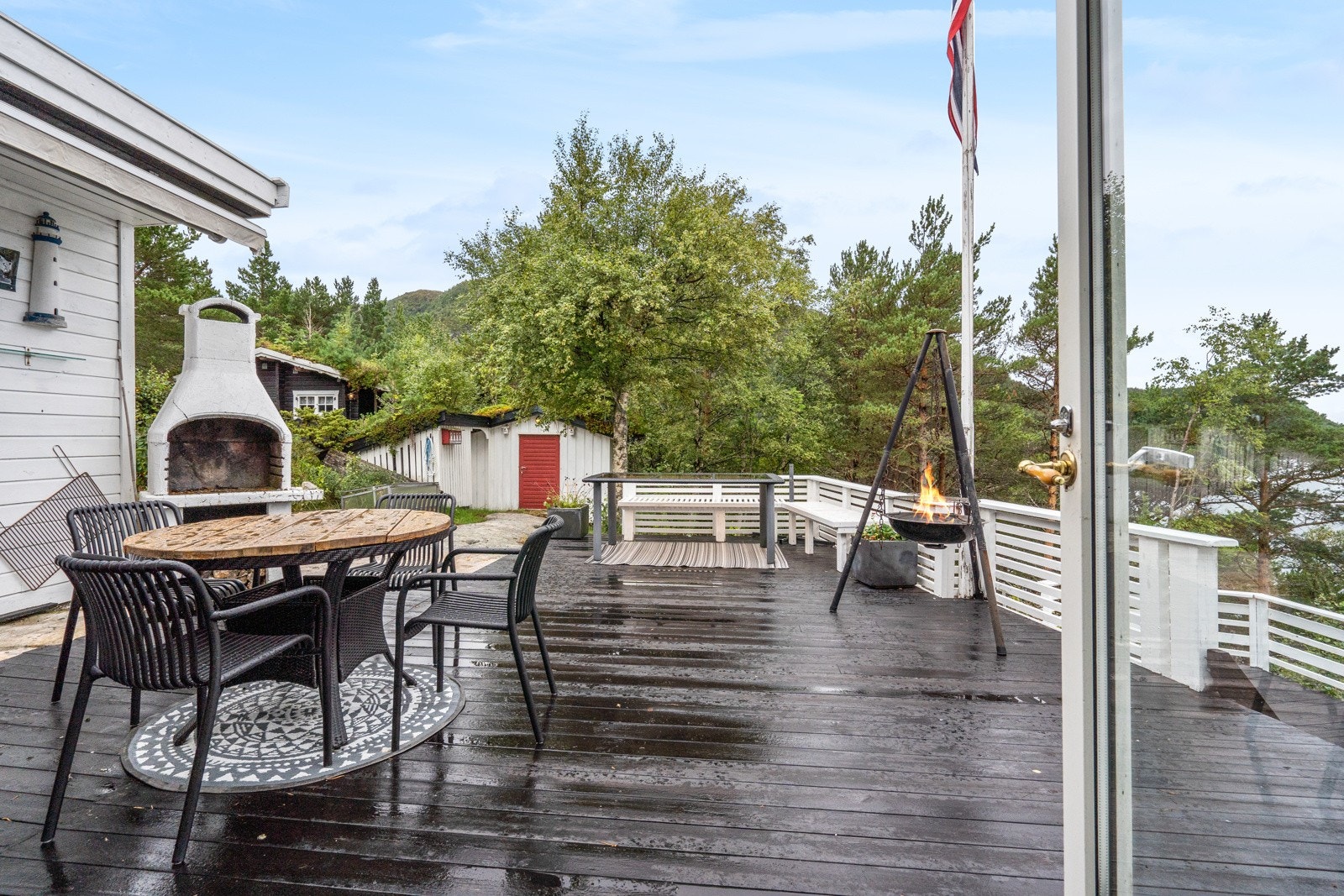 I hjørnet av terrassen skaper en utepeis ekstra hygge på sene sommerkvelder. Galleribilde