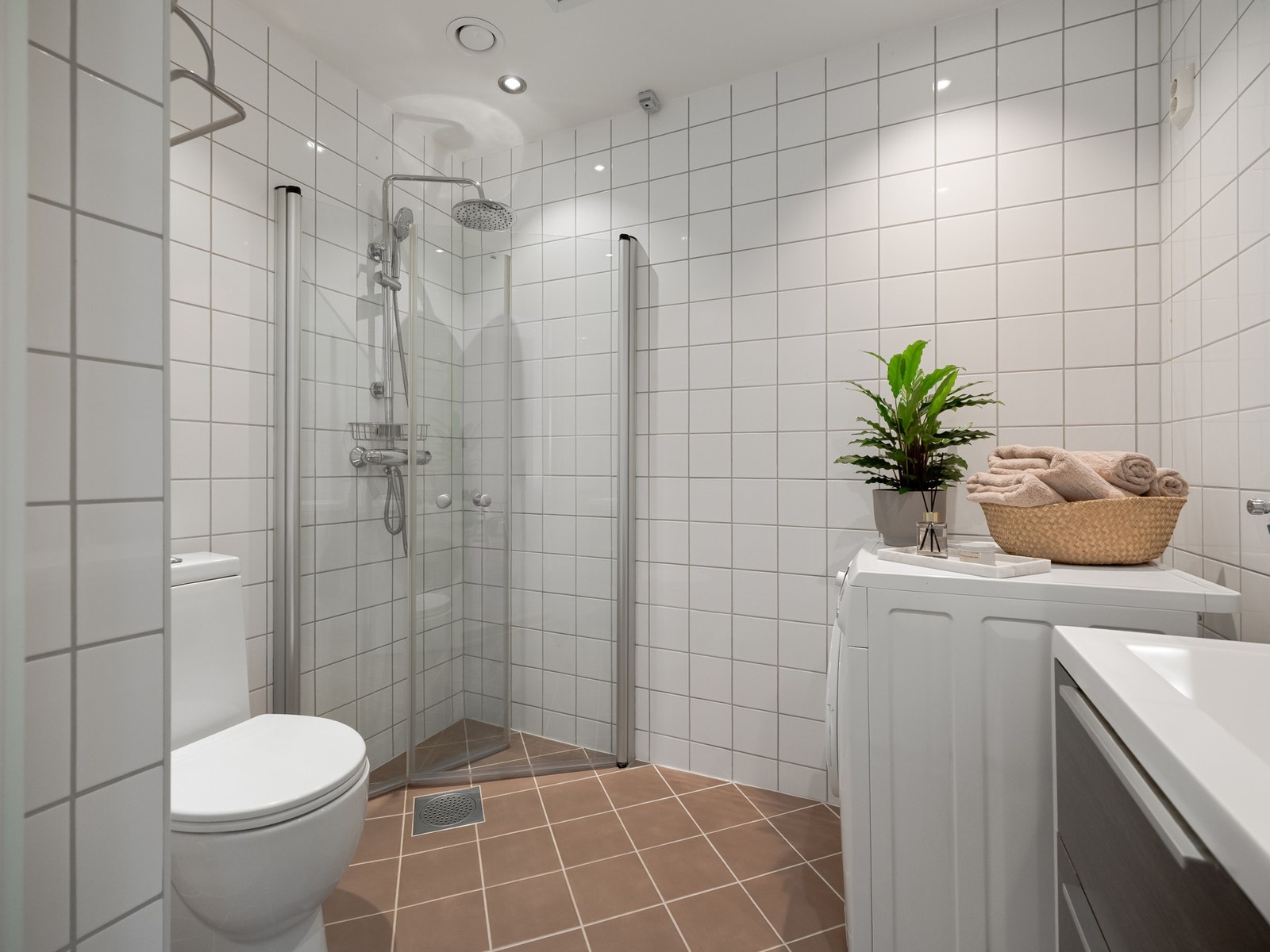 Badet er pent flislagt og innredet med dusjhjørne med glassdører, toalett, servantskap med oppbevaring og speilskap på vegg. I taket er det mekanisk avtrekk for god utlufting. Galleribilde