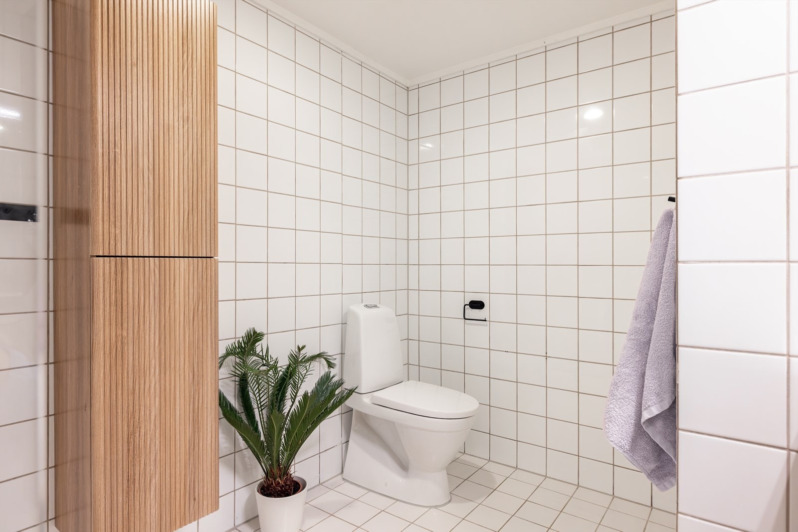 Badet er innredet med servant i skuffeseksjon, speilskap og høyskap for oppbevaring. Galleribilde