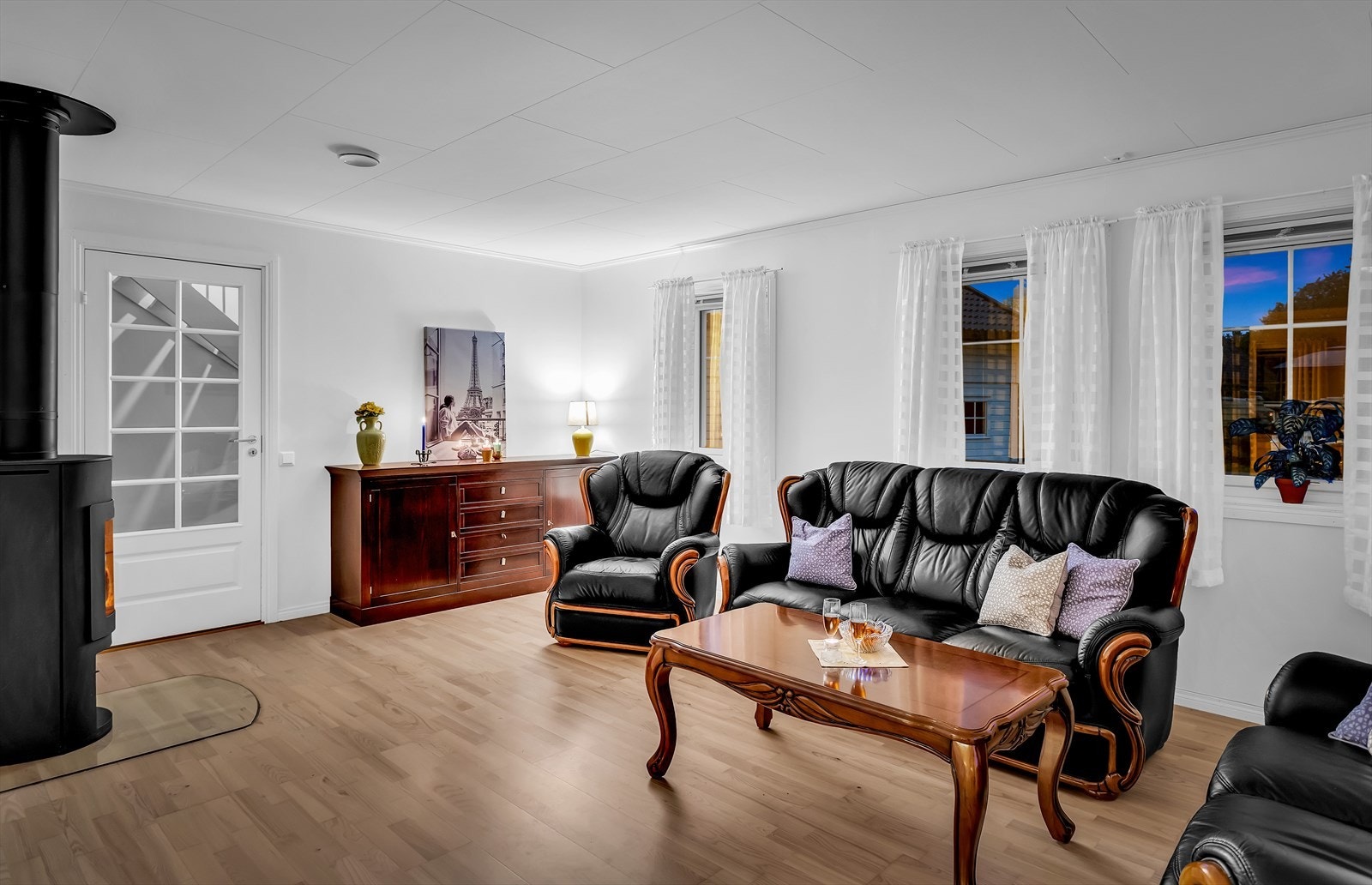 Stilrene overflater og store vinduer gir en behagelig og innbydende stue. Galleribilde