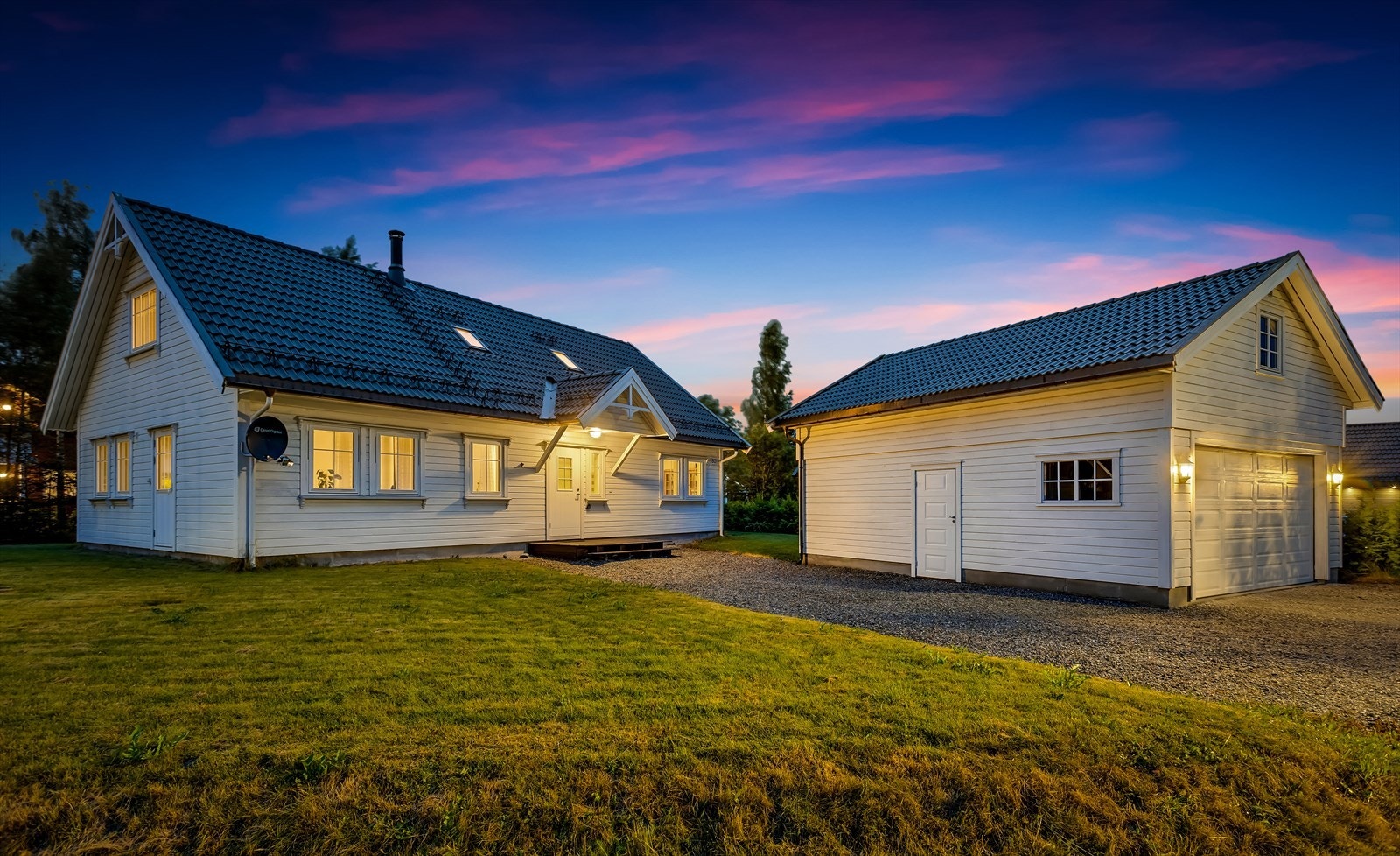 Boligen fremstår innbydende også på kveldstid, med godt opplyst fasade og garasje. Galleribilde