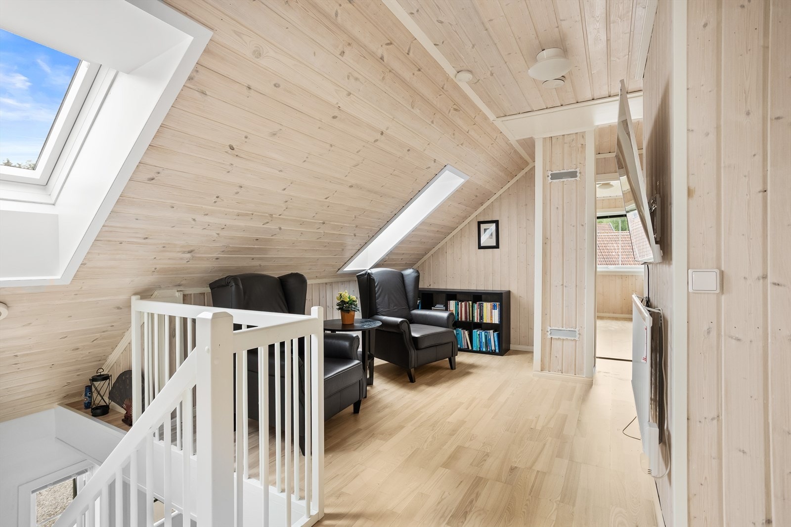 Loftstuen har skråtak og store takvinduer som gir en behagelig romfølelse. Galleribilde
