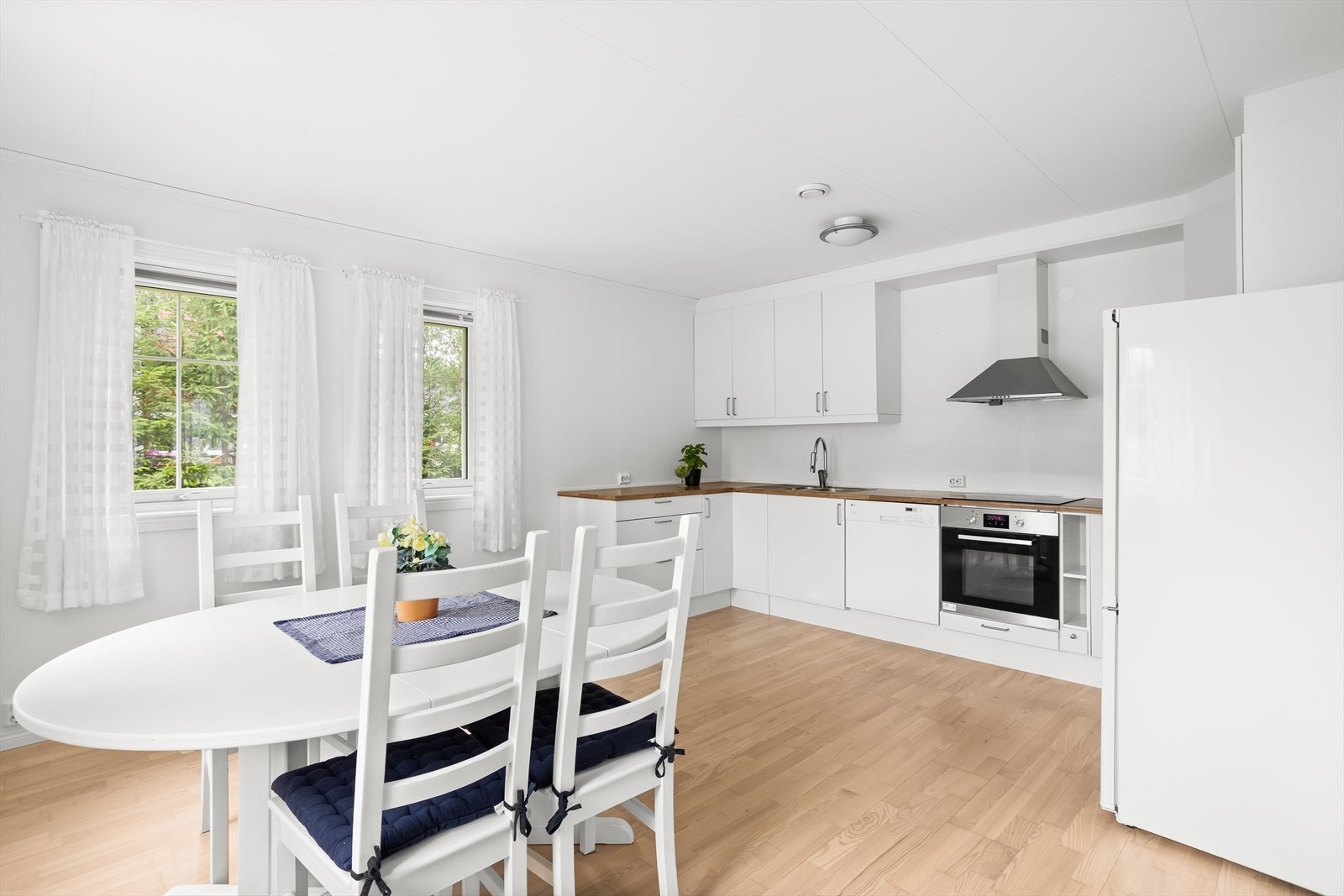 Delikat kjøkken med glatte fronter, laminert benkeplate og god plass til spisebord. Galleribilde