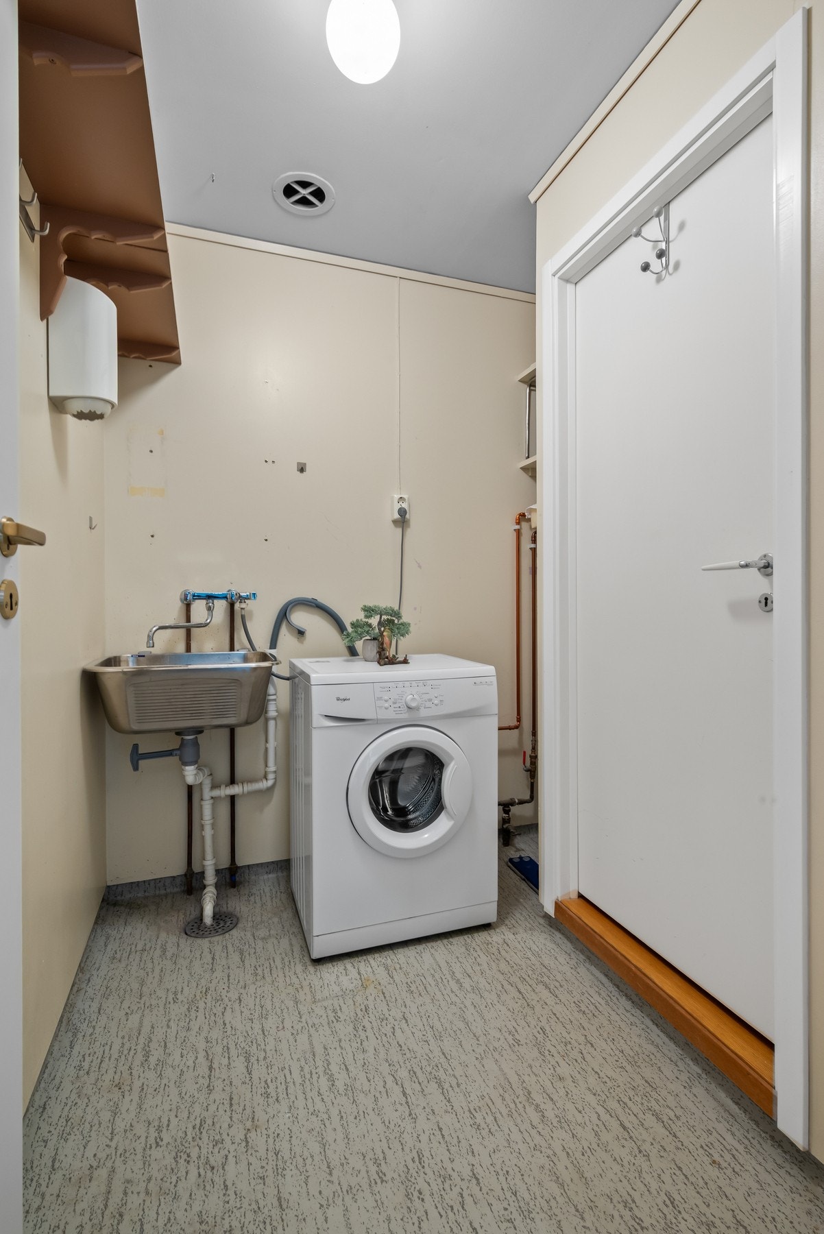 Vaskerom utstyrt med Veggmontert skyllekar, tilkobling for vaskemaskin og varmvannsbereder. Galleribilde