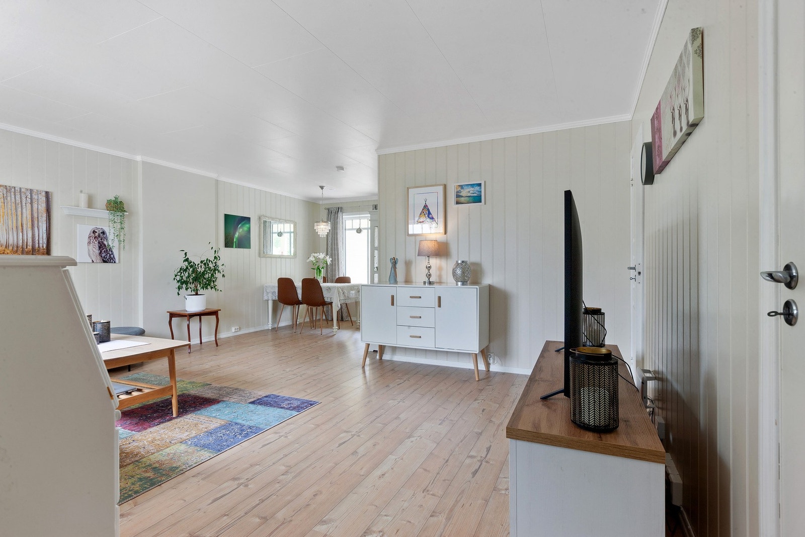 Lys og romslig stue med god plass til sofagruppe og spisebord med tilhørende møblement Galleribilde