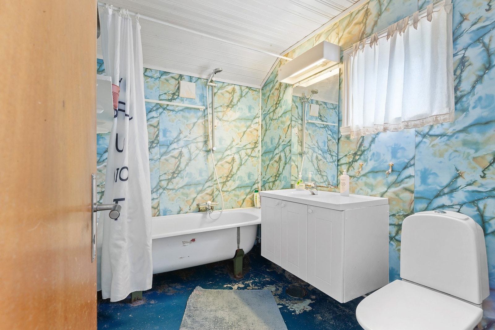 Baderommet er bestående av servant med underskap, badekar og toalett Galleribilde