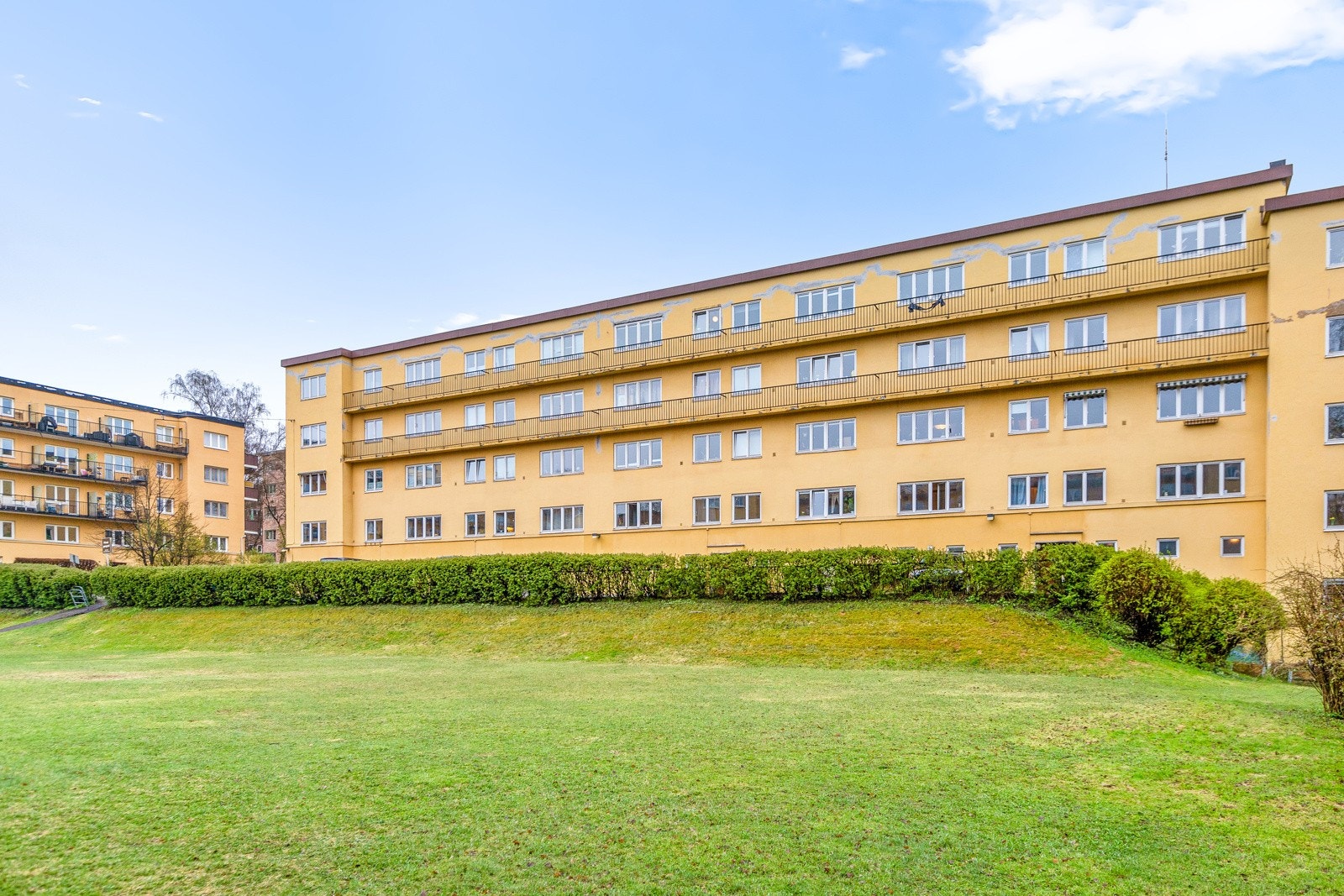 Like ved leiligheten er det en stor åpen gressplen som beboerne i området benytter seg av. Her vil man være skjermet for biltrafikk og støy. Galleribilde