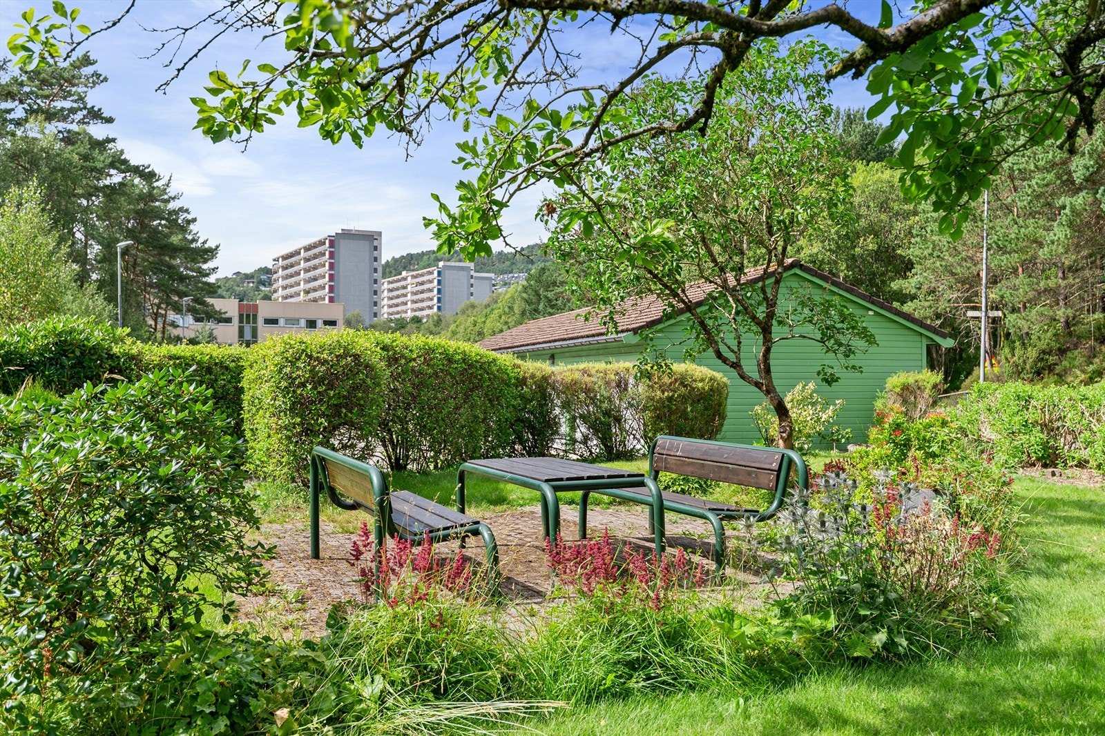 Nyt de fine dagene med en kaffe og noe godt til på en av benkene i nabolaget Galleribilde