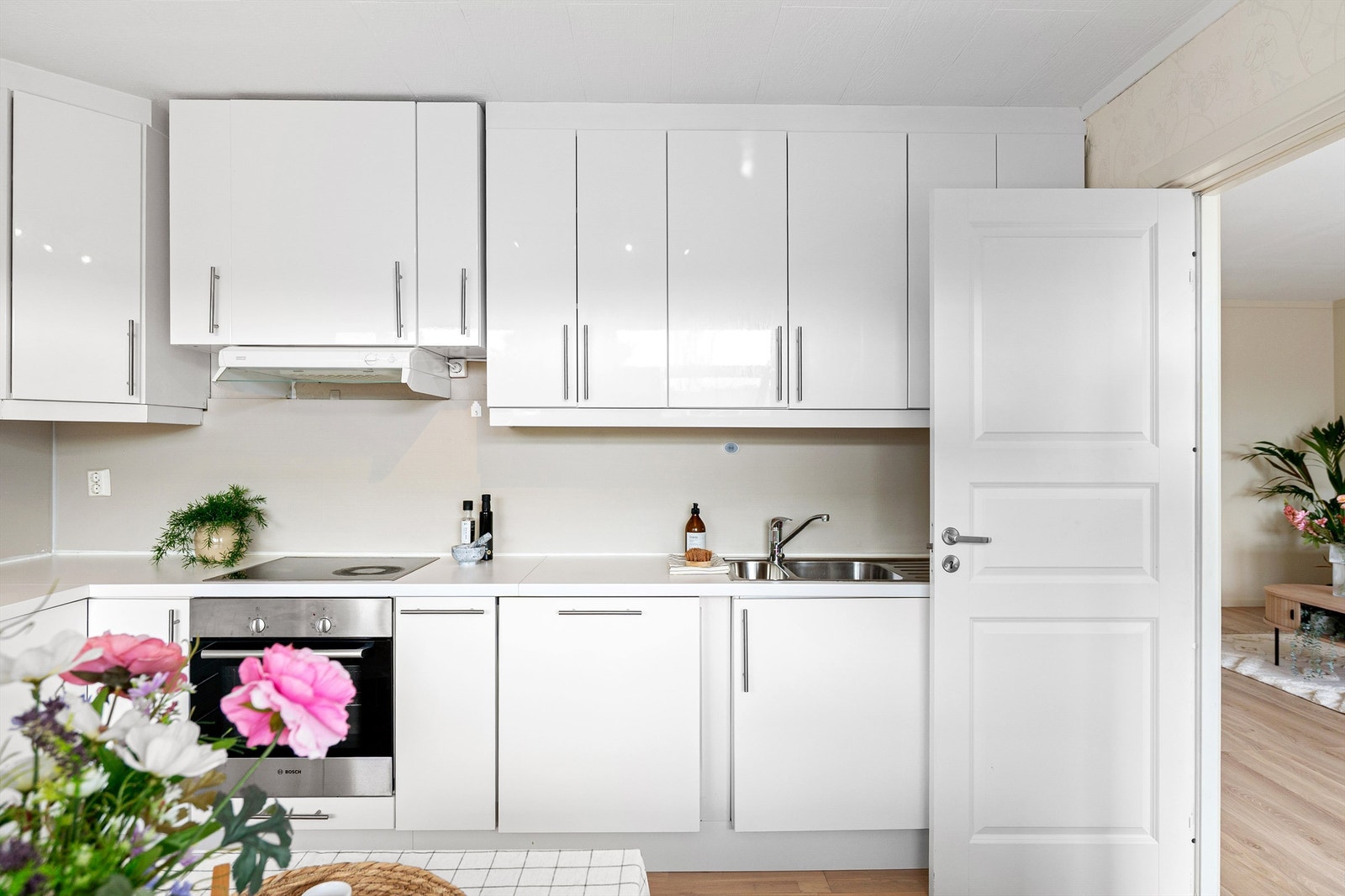 Klassisk og tidløs kjøkkeninnredning med hvite fronter samt integrert platetopp, stekeovn og oppvaskmaskin. Galleribilde