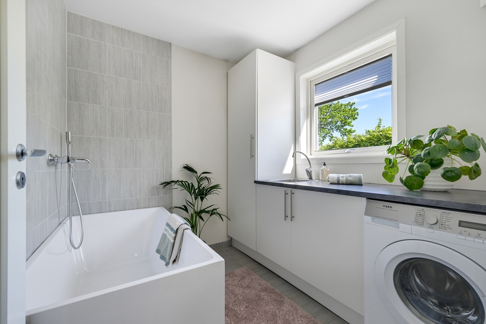 Vaskerom hvor det er satt inn badekar og fliselagt vegger ved karet. Innredning med utslagsvask. Galleribilde