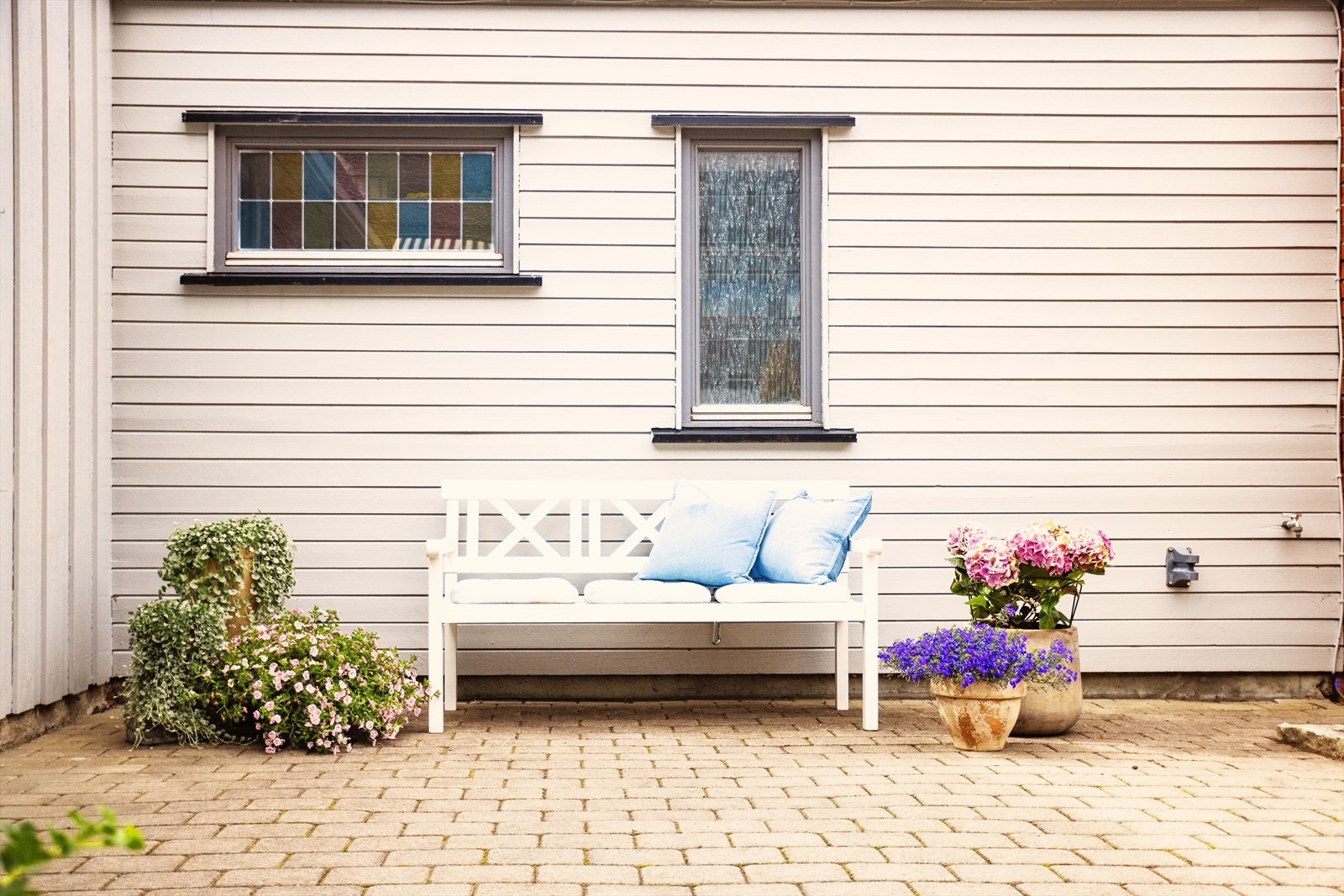 Steinsbelagt uteplass med gode muligheter for å ha utemøblement. En sosial uteplass. Galleribilde