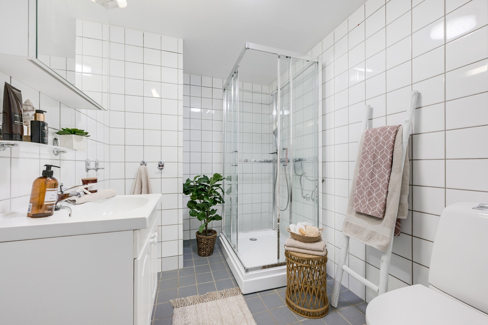 Lyst og flislagt bad med servant, wc og dusjkabinett. Galleribilde