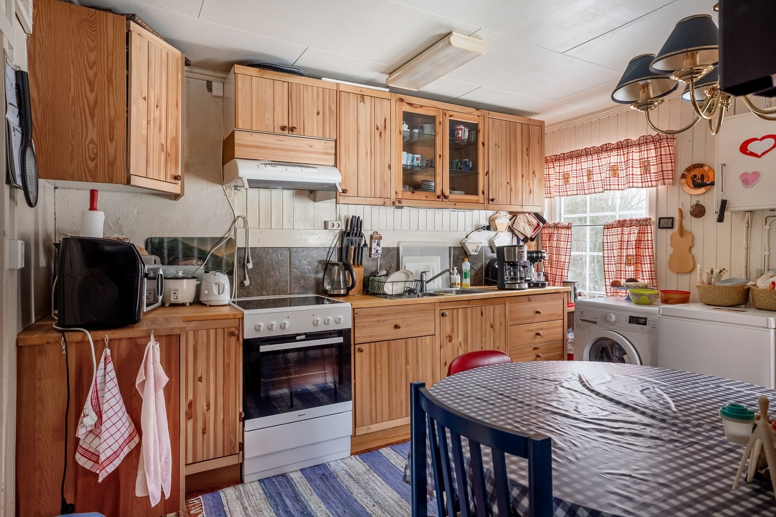 Fra gangen kommer du inn i kjøkkenet som har heltre innredning og opplegg for vaskemaskin. Galleribilde