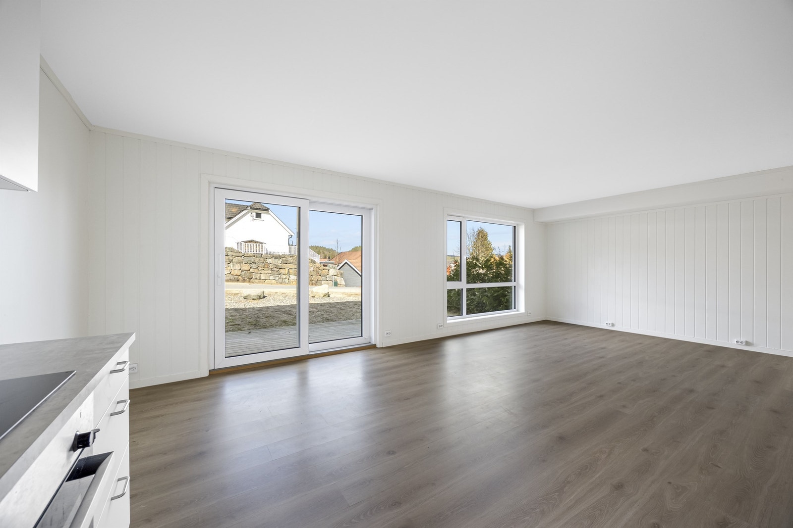 Stor stue med skyvedør til uteplassen tilhørende leiligheten Galleribilde