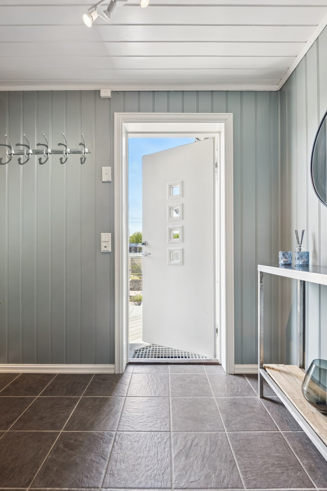 Entré med fliser og plass til yttertøy, samt direkte tilgang til terrasse ved inngangspartiet. Galleribilde