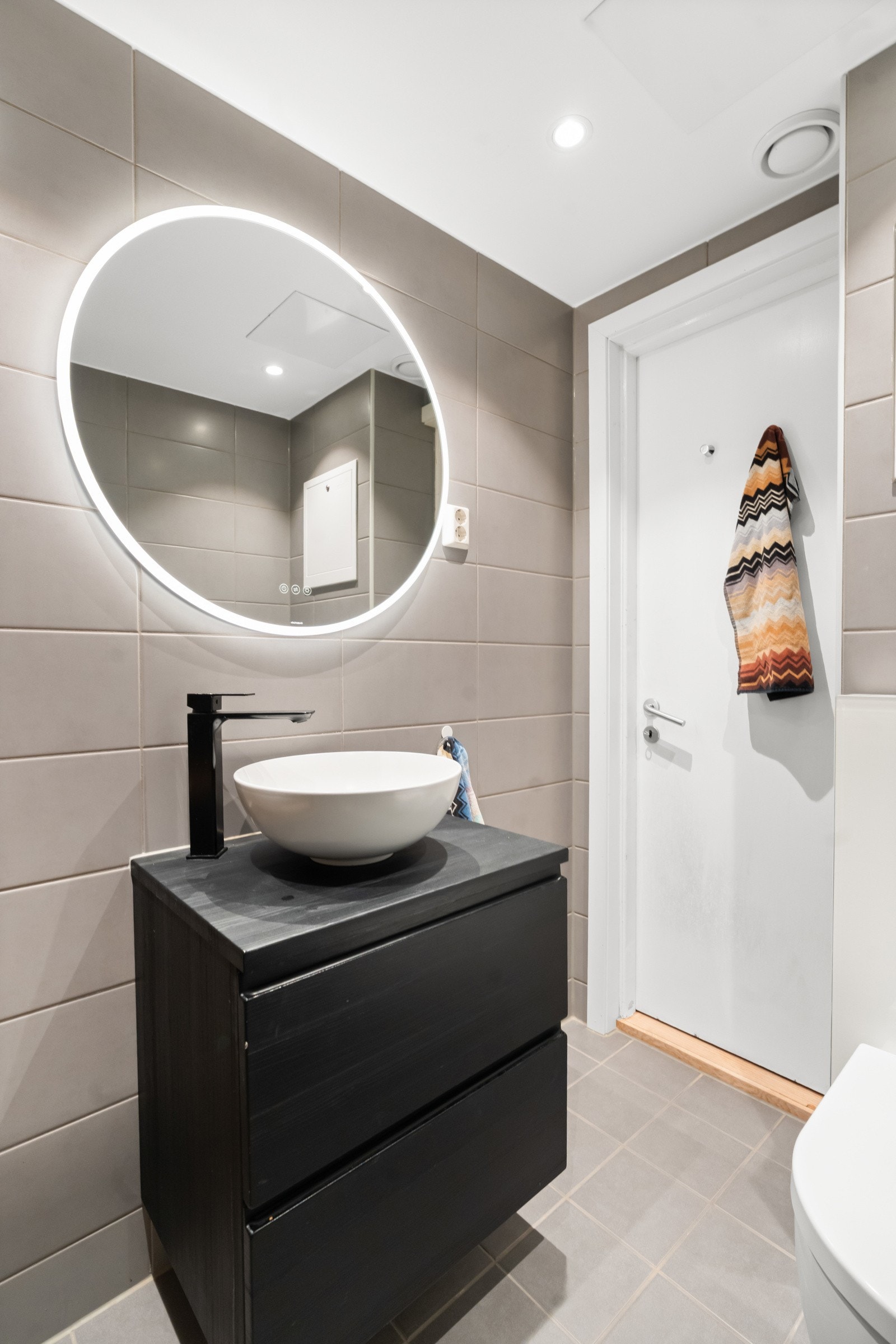 Badet består av vegghengt toalett, dusjhjørne med to foldbare glassdører og servant med skap med slette fronter. Badet har fortsatt garanti. Naturlig ventilasjon. Galleribilde