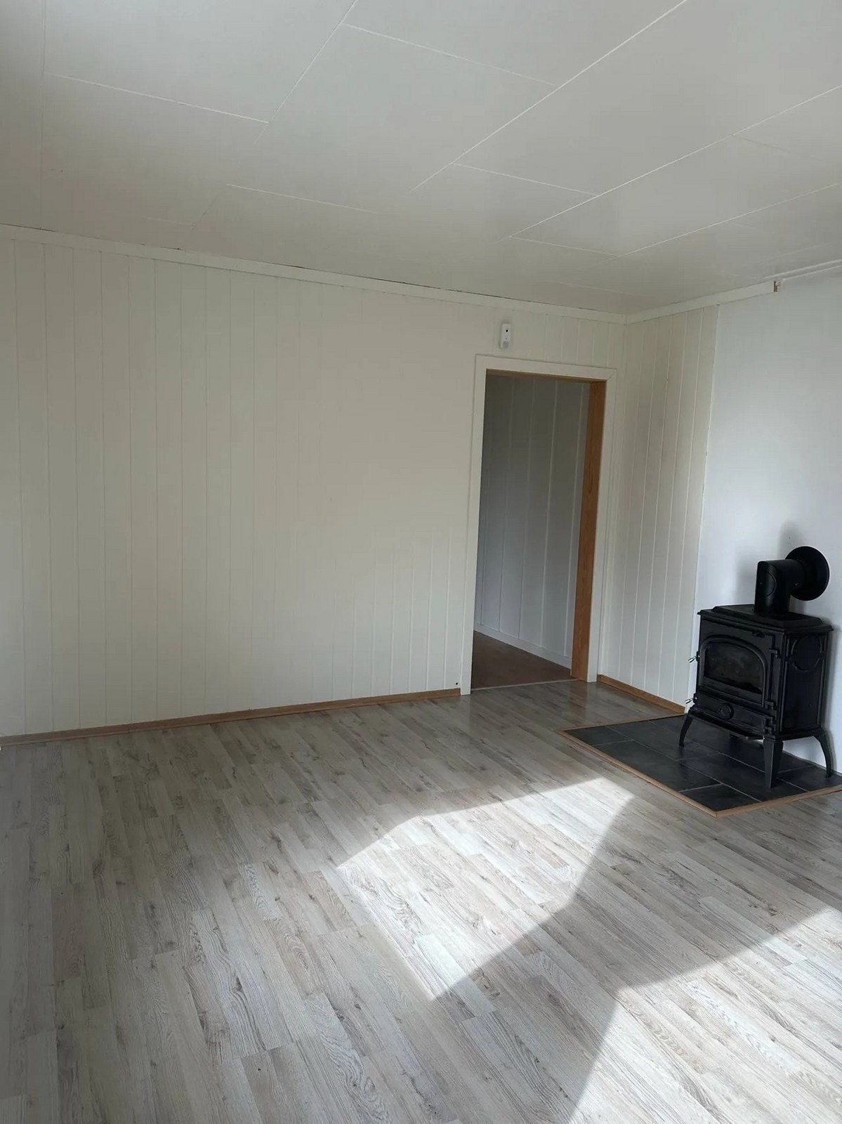 Stuen har lyse overflater og vedovn. Galleribilde