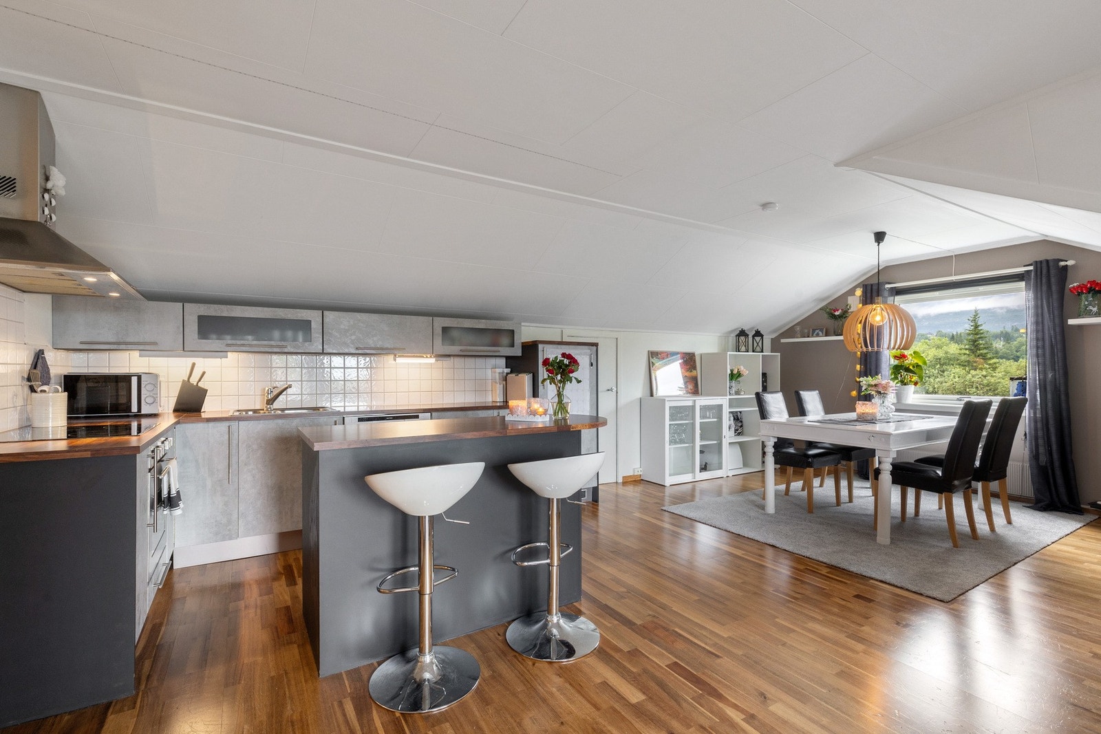 Med spiseplassen i direkte tilknytning til kjøkkenet bidrar det til flere sosiale soner selv ved matlaging Galleribilde