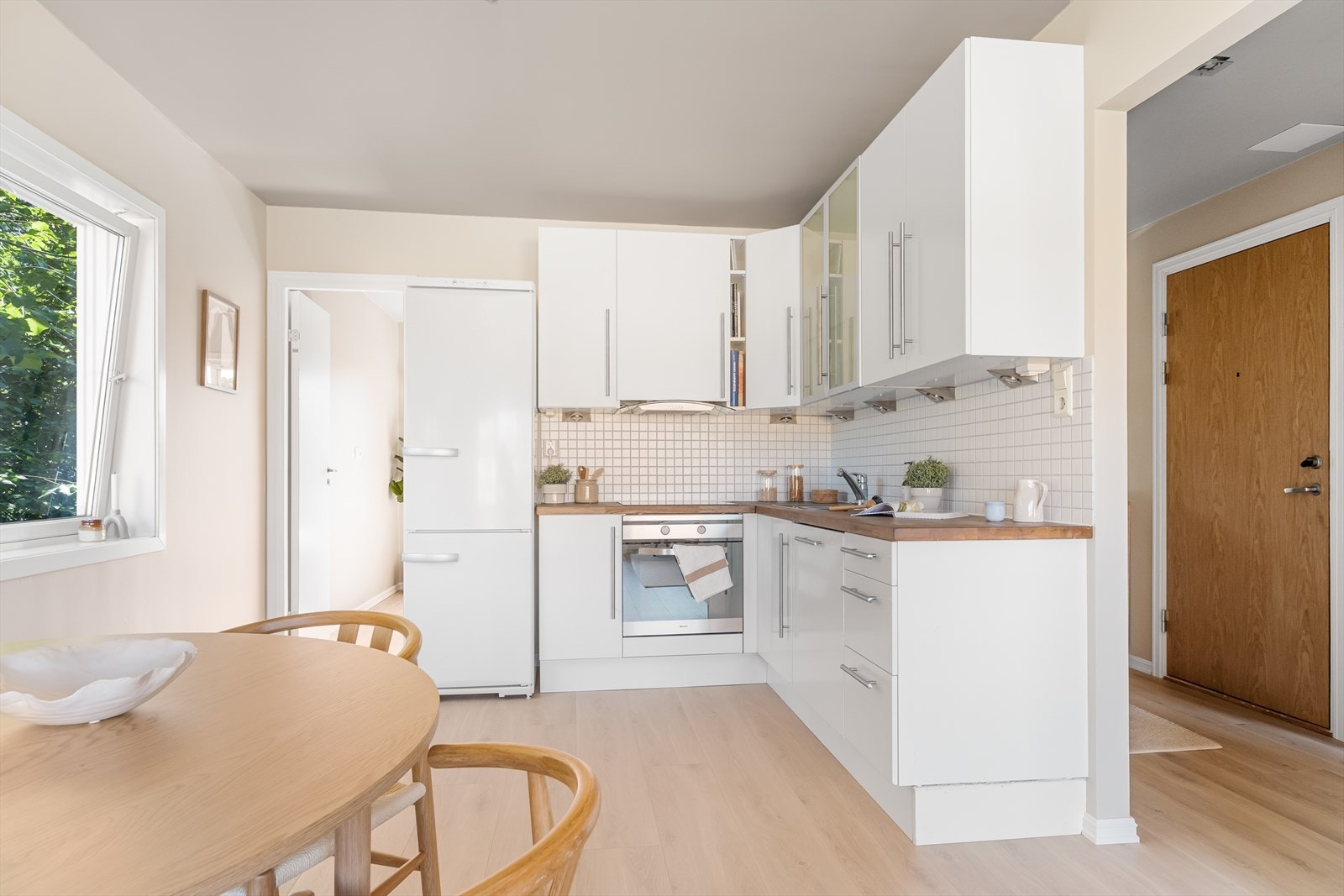 - Kjøkkeninnredning med glatte fronter, heltre benkeplate med nedfelt vask- og skyllekum, samt fliser og belysning over benkeplaten - Galleribilde