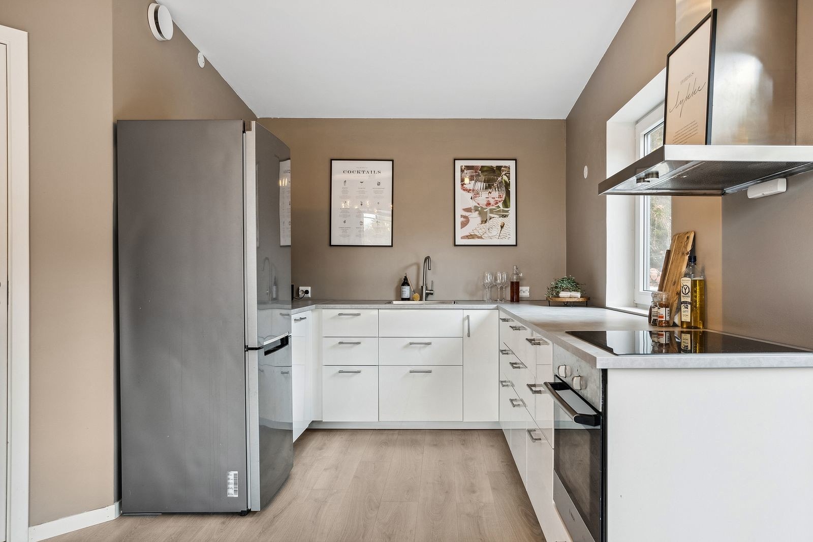 Kjøkkenet er utstyrt med integrert oppvaskmaskin, stekeovn og induksjonstopp Galleribilde