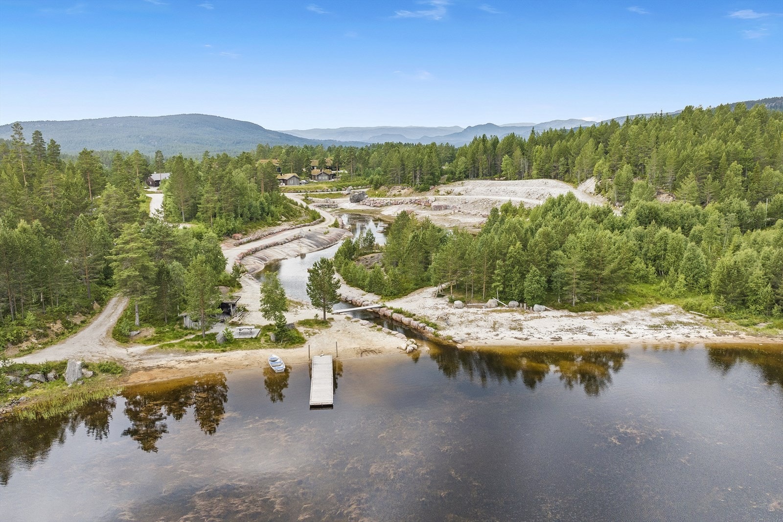 Nede ved innsjøen har hytteområde brygge, sittegrupper og nydelig sandstrand. Galleribilde