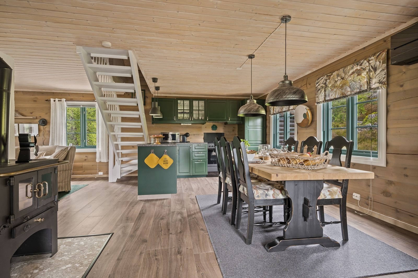 Med både vedovn og varmepumpe i tillegg til peisen får man det varmt og godt i allrommet. Galleribilde