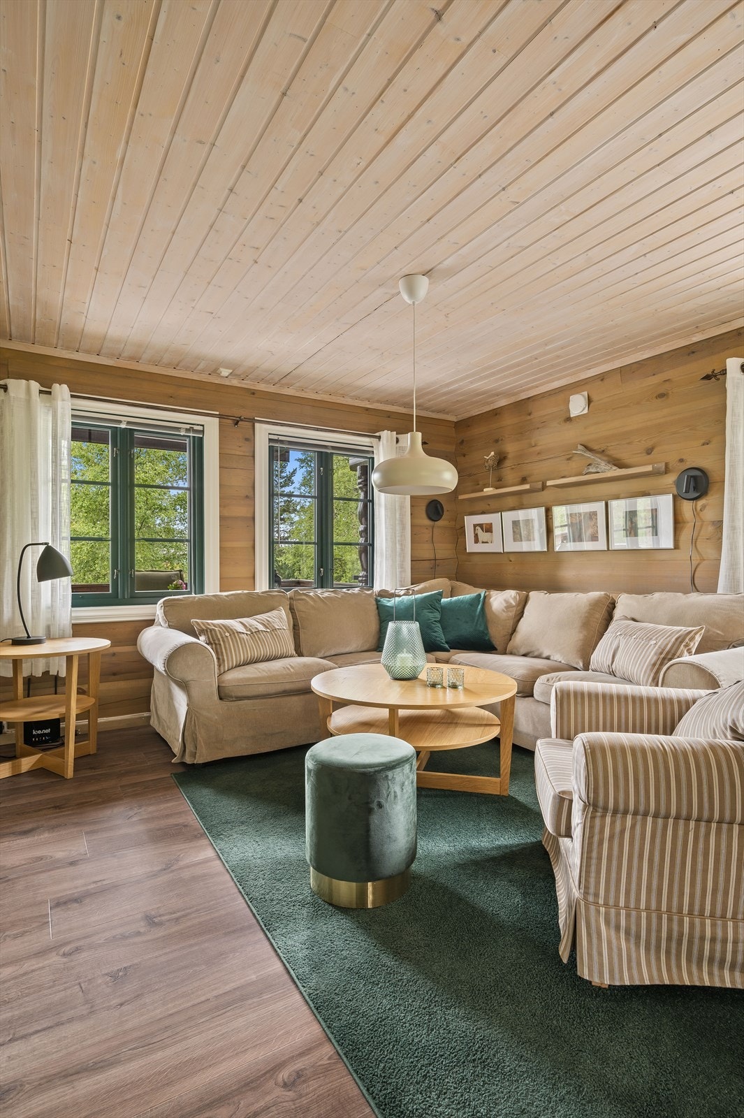 Atmosfæren er lun og god, understreket av mørke overflater i stuen. Galleribilde