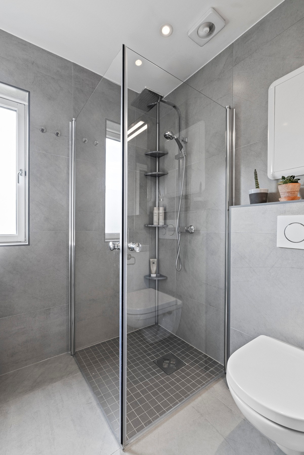 Badet har flislagte gulv og vegger, gulvvarme og integrerte downlights Galleribilde