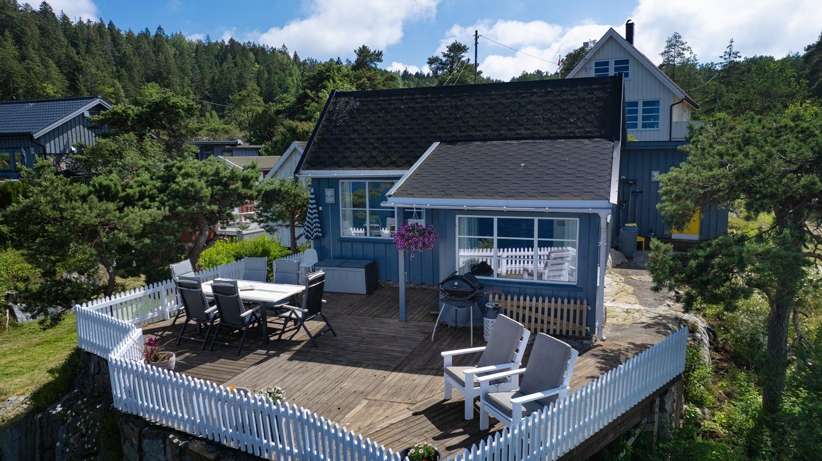 Eiendommen har fine uteplasser, blant annet terrasse mot sjøen med kveldssol. Galleribilde