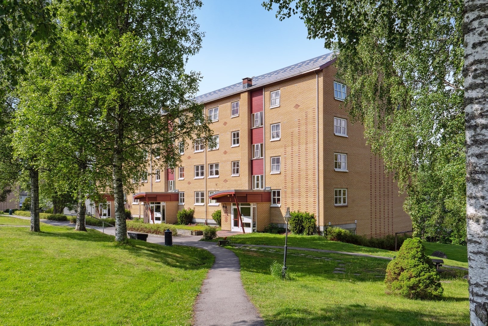 Blokkene har pene teglstensfasader og takoverbygget inngangsparti med porttelefon Galleribilde