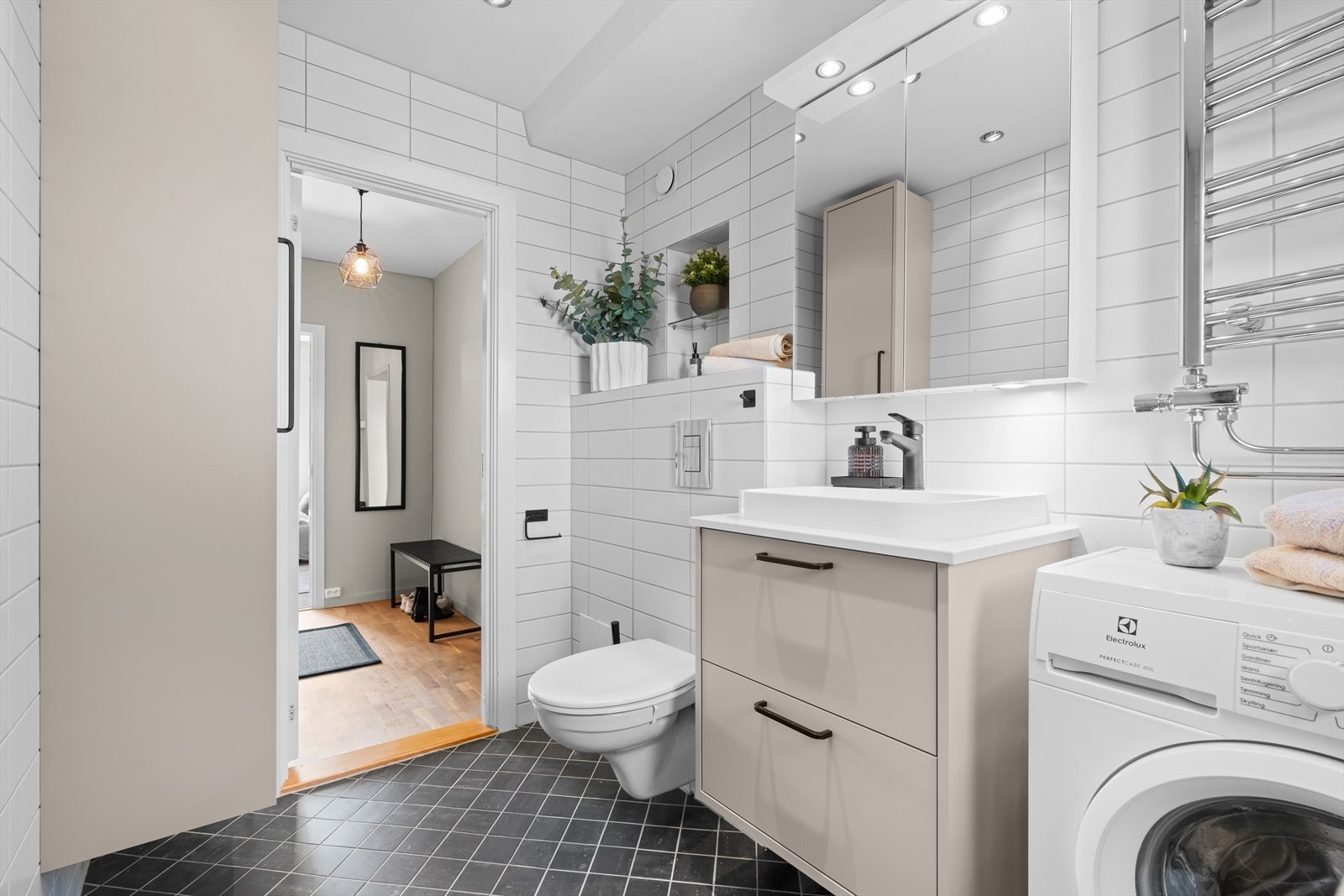 Rommet har dusj på gulv med dører i herdet glass, samt opplegg for vaskemaskin. Baderomsinnredning, oppbevaringsskap, dusj og dusjaramtur/blandebatteri ble byttet ut i 2025. Baderommet ble totalrenovert i 2008 ifølge selger. Galleribilde