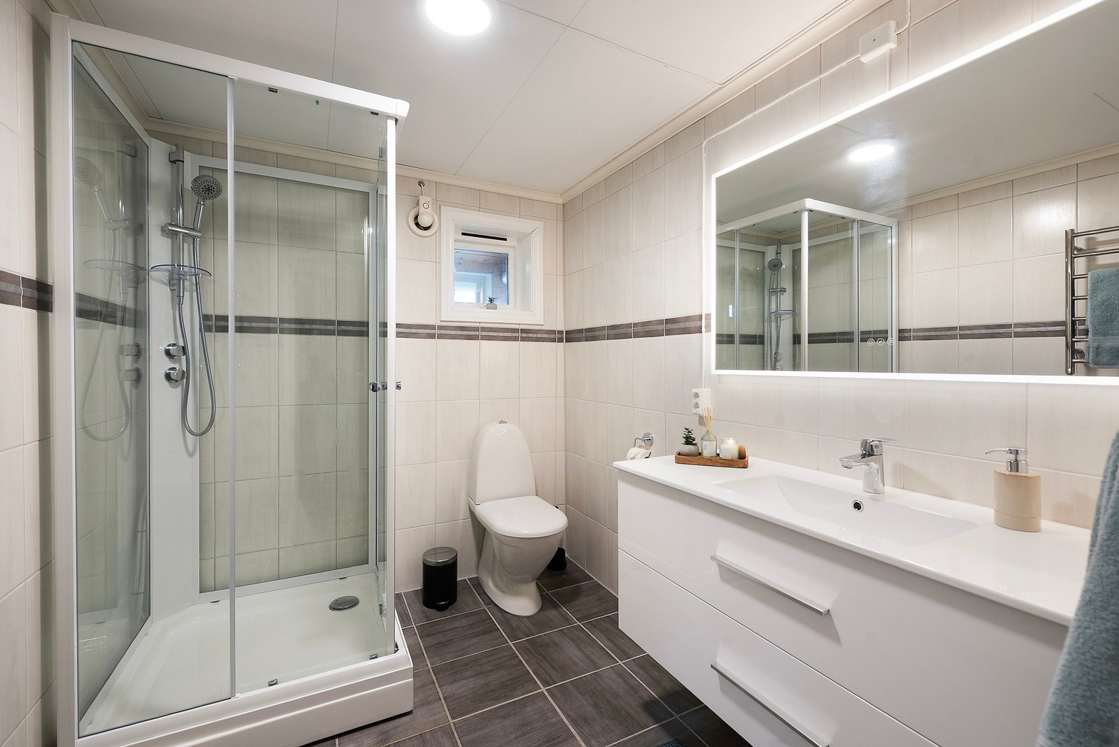 Badet er flislagt med varme i gulvet, dusjkabinett og nyere servant som gir god oppbevaringsplass. Galleribilde