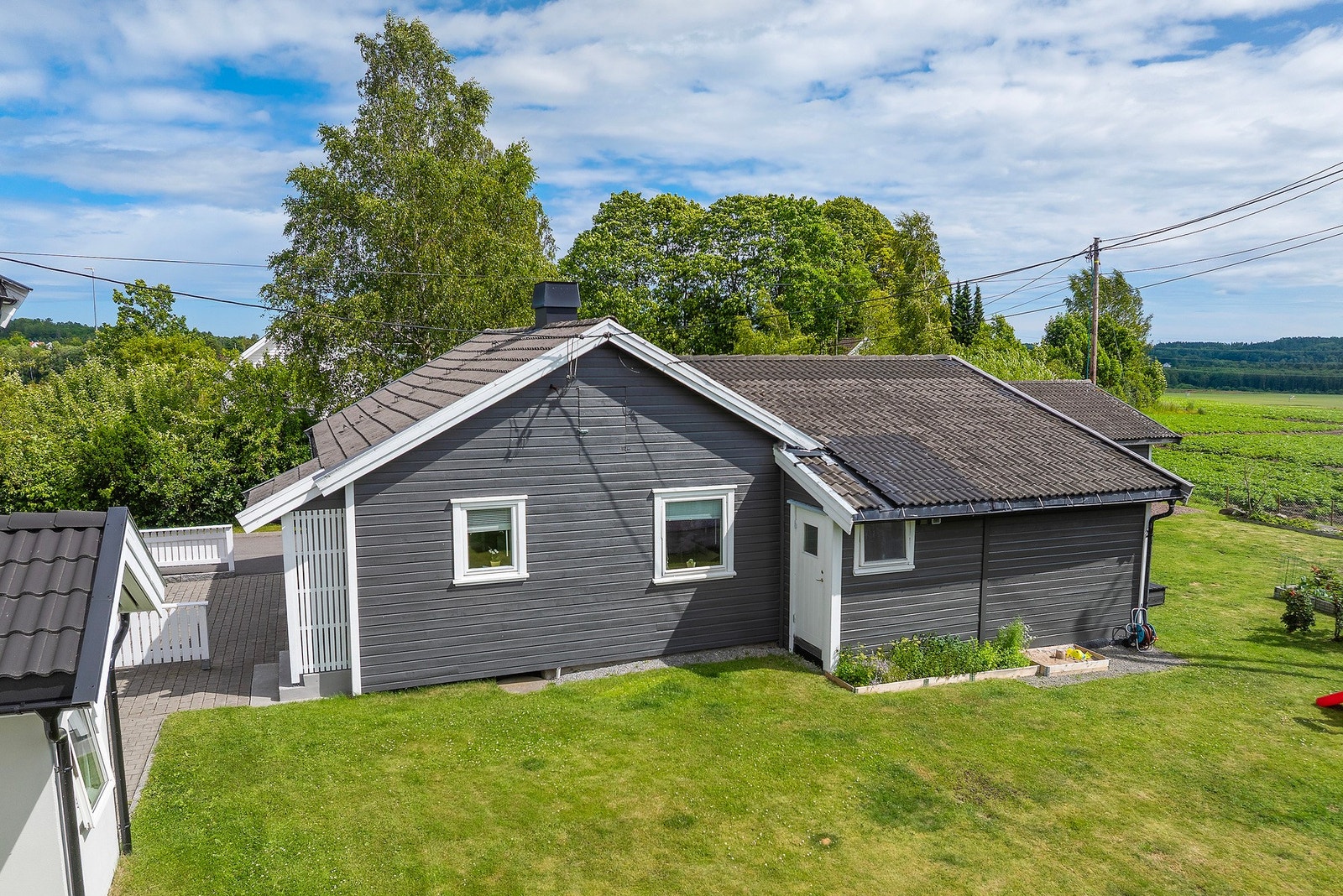 Tilnærmet flat tomt med store plenarealer - døren inn her er til boden. Galleribilde