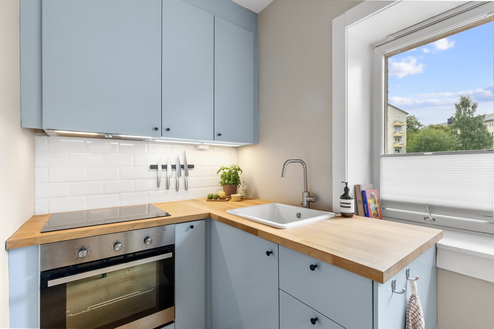 Kjøkkeninnredning med slette fronter og integrert platetopp og stekeovn. Galleribilde