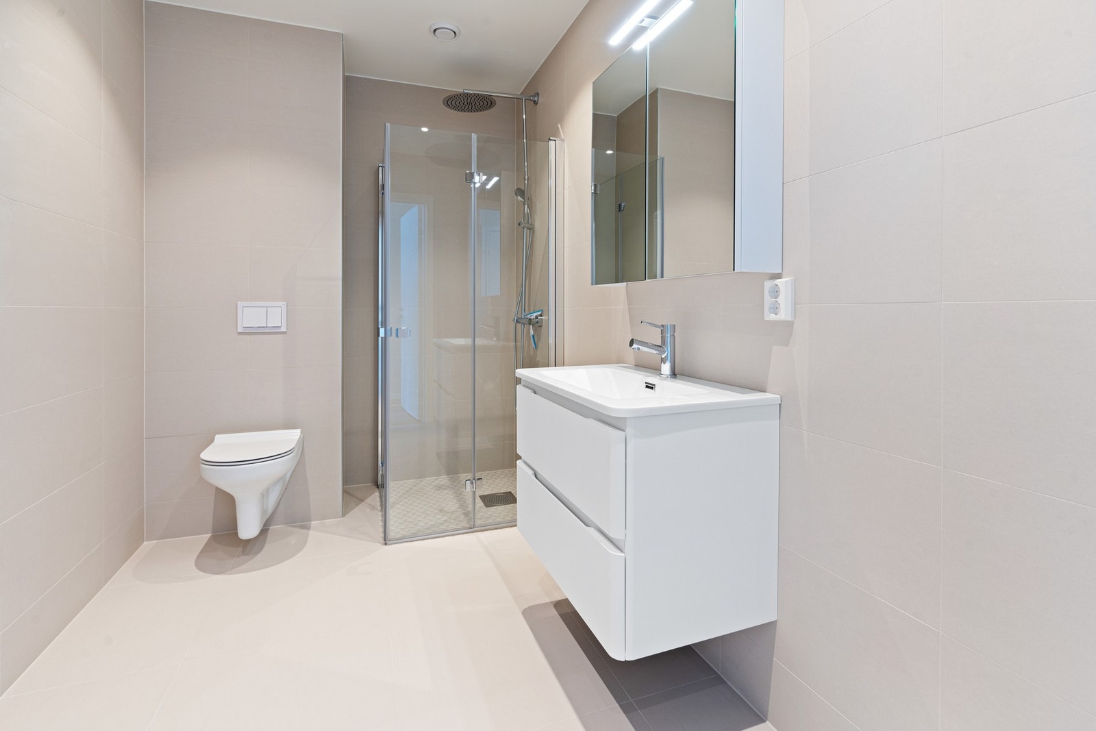 Badet har vegghengt toalett og moderne duse farge på vegg og innredning. Galleribilde